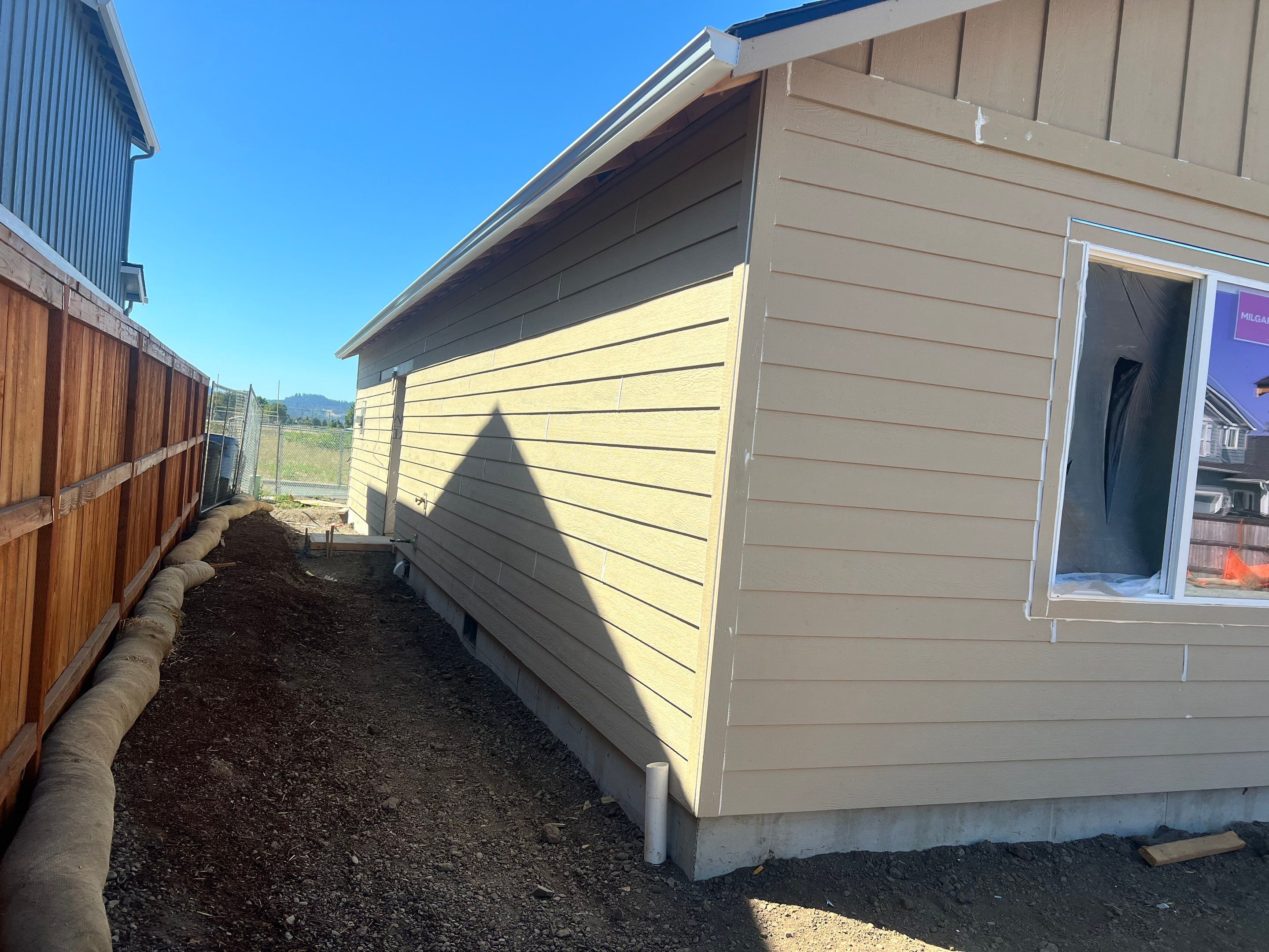 Continuous White Gutter and Downspout Installation for New Eugene Home by BEST Roofing & Waterproofing