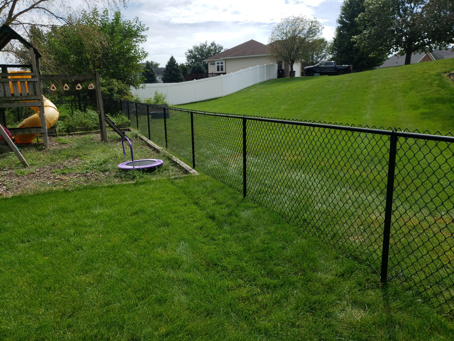 Black Vinyl-Coated Chain Link Fence Installation in Cedar Falls by Perfect Picket Fence and Stain