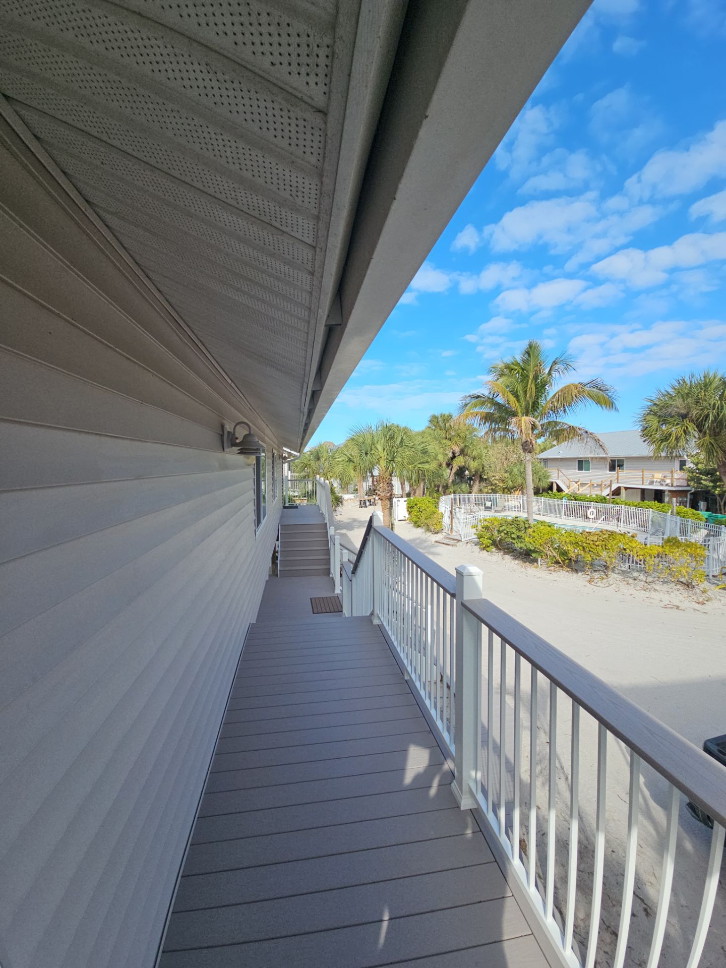 Elevated Home Deck Reconstruction With White Aluminum Railings in Placida by Smirnov Construction Inc