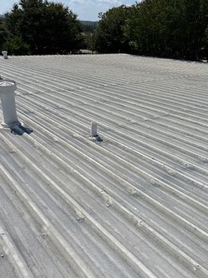 Corrugated metal roof surface with vents and blue sky