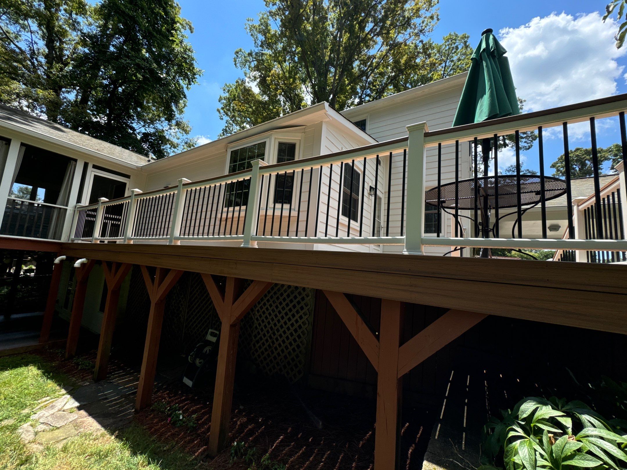 pressure washing company cleaning wooden deck and house siding