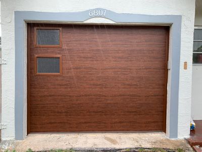 Sectional Garage Door Installation with Wood-Grain Finish in Sunrise - Clopay Modern Steel