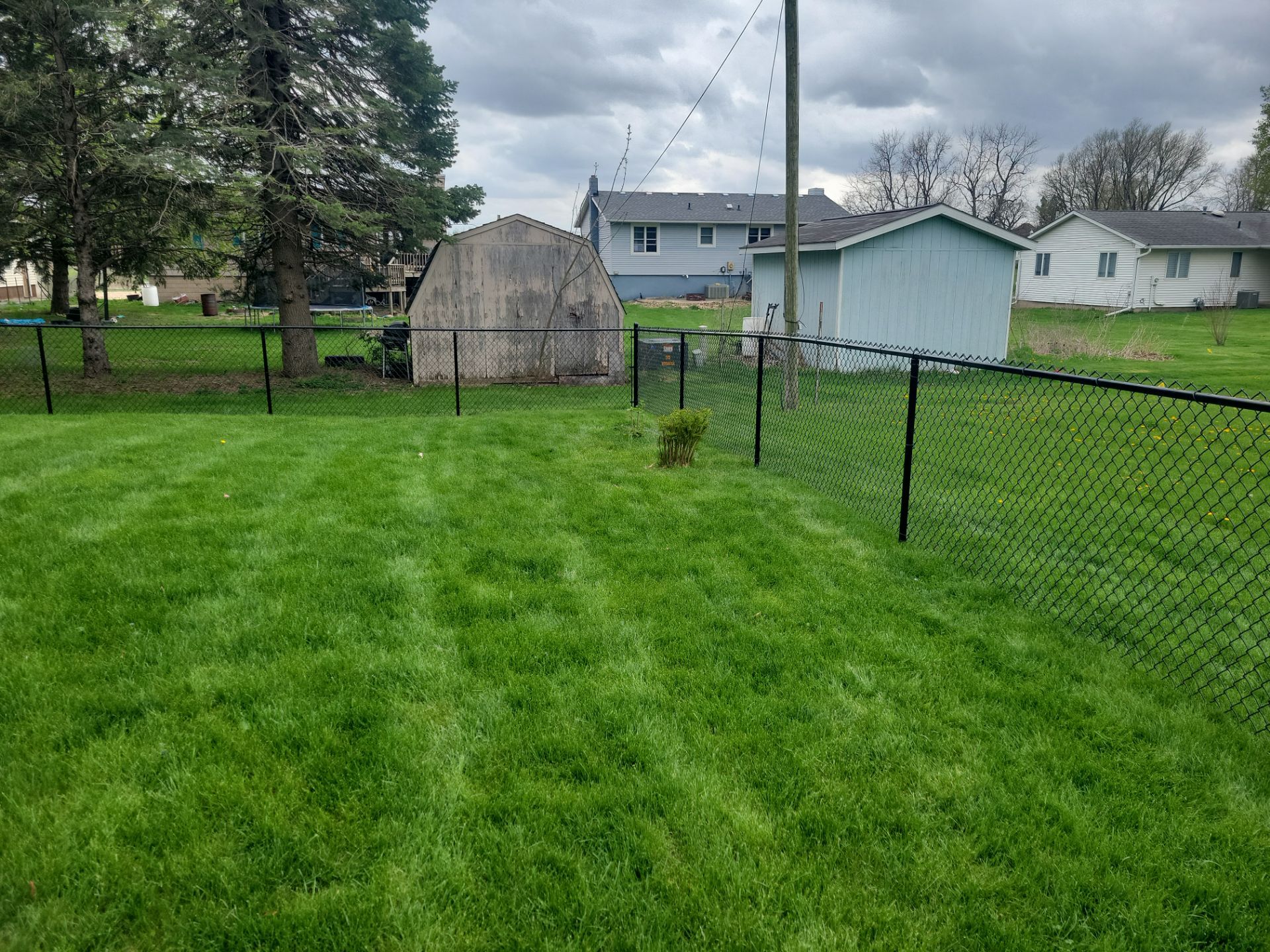 Residential Black Vinyl-Coated Chain Link Perimeter Fence in Garwin by Perfect Picket Fence and Stain