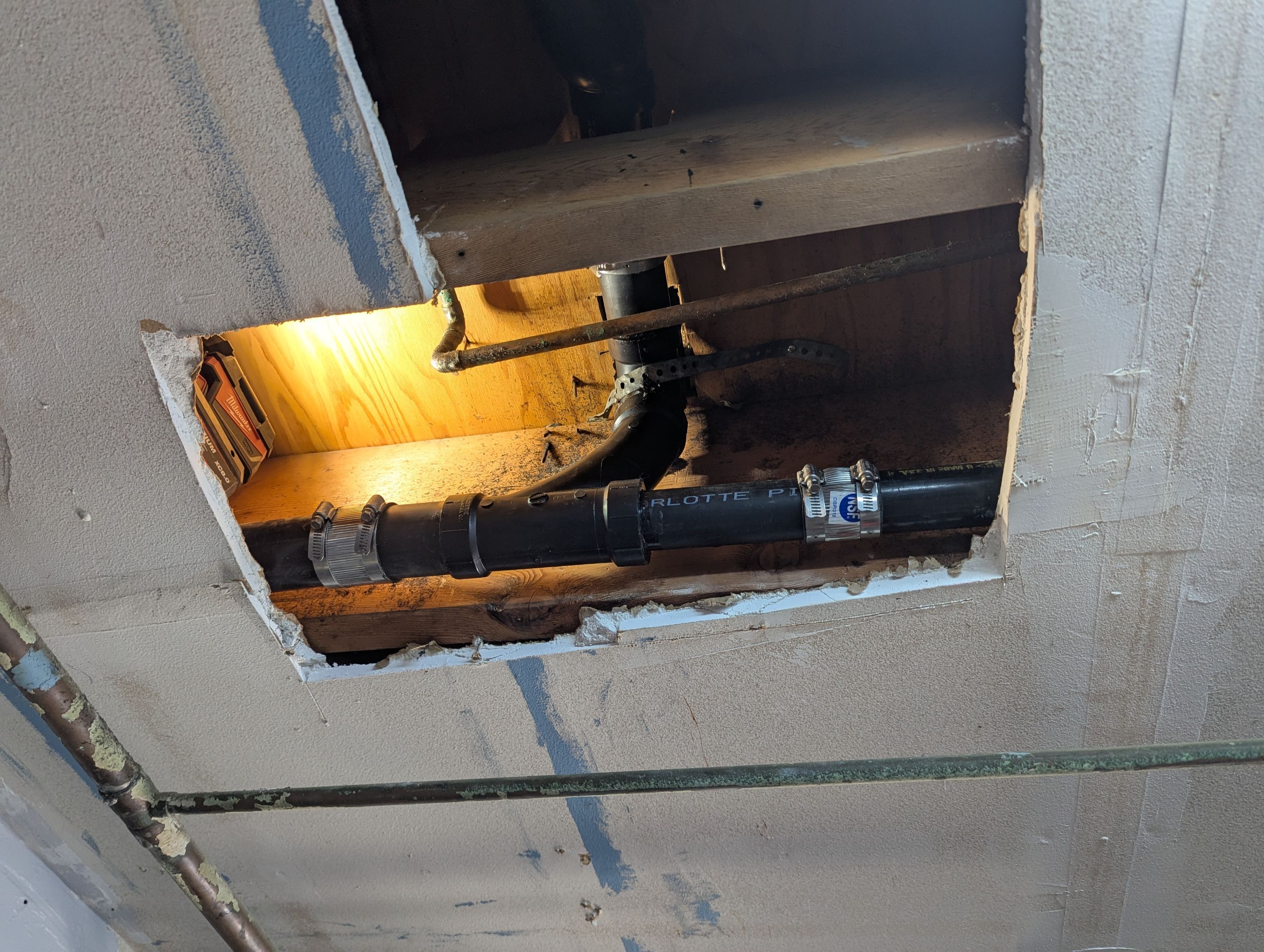 Drain line leak in garage ceiling by Professional Plumbing Inc 