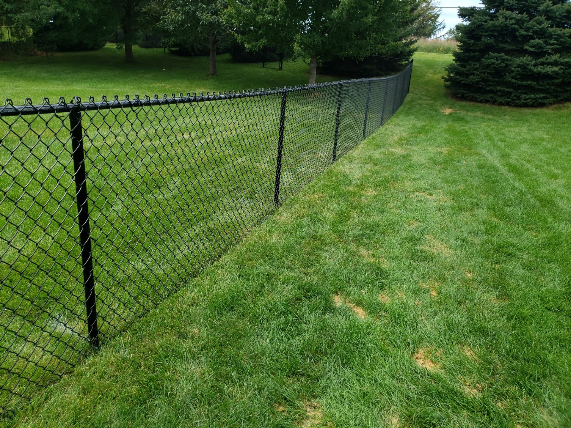 Black Vinyl-Coated Chain Link Fence Installation in Cedar Falls by Perfect Picket Fence and Stain
