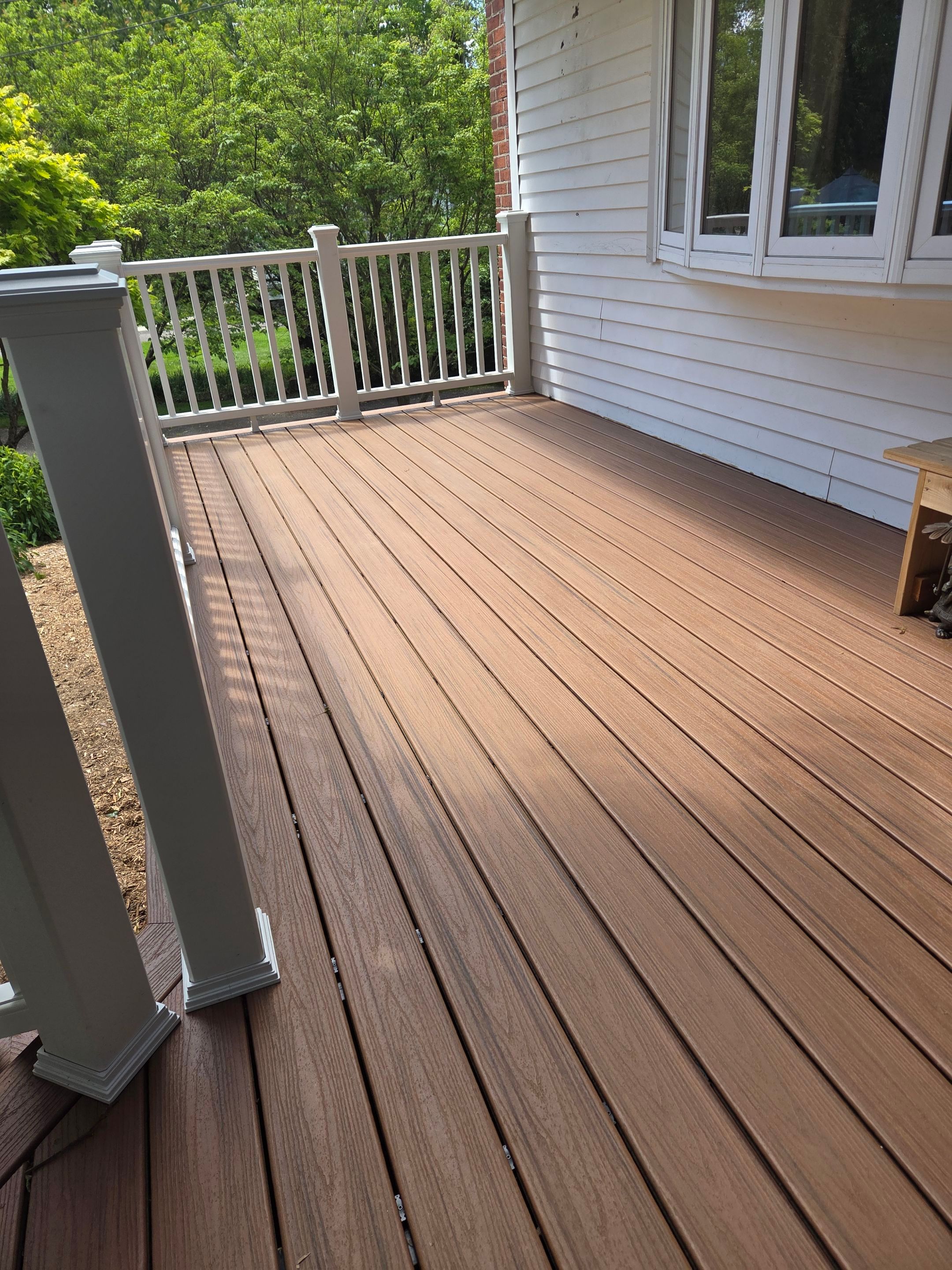 Deck Replacement, Trex Tiki torch boards, with White composite railing and lattice. by DiGiorgi Roofing and Siding Inc