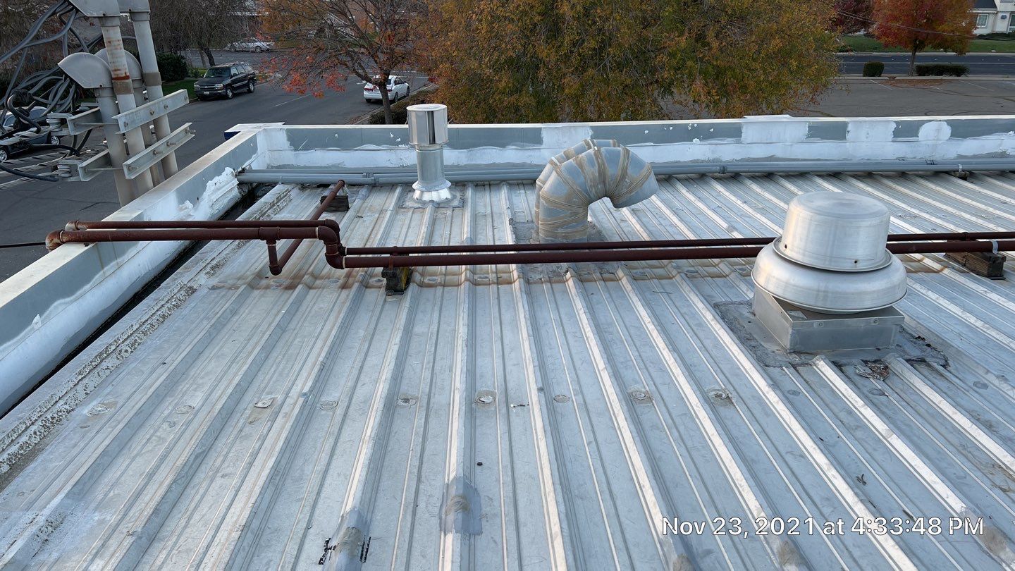 Metal roof restoration on commercial roof using Conklin Benchmark/ PUMA XL acrylic coatings over metal and foam by Straight Edge Roofing Inc