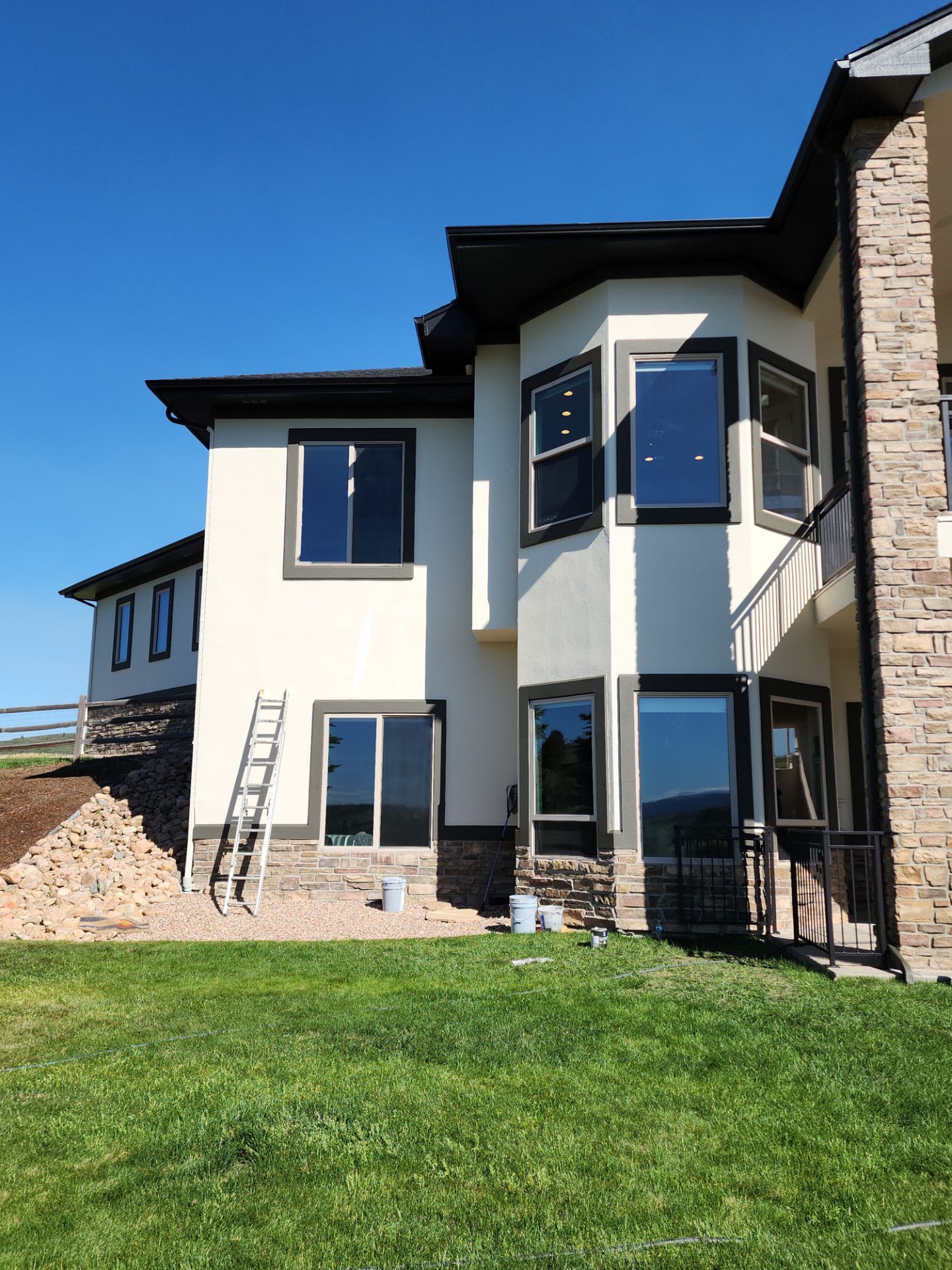 Castle Rock Elegance: White Stucco Exterior with Bold Tricorn Black by J&M Painting LLC