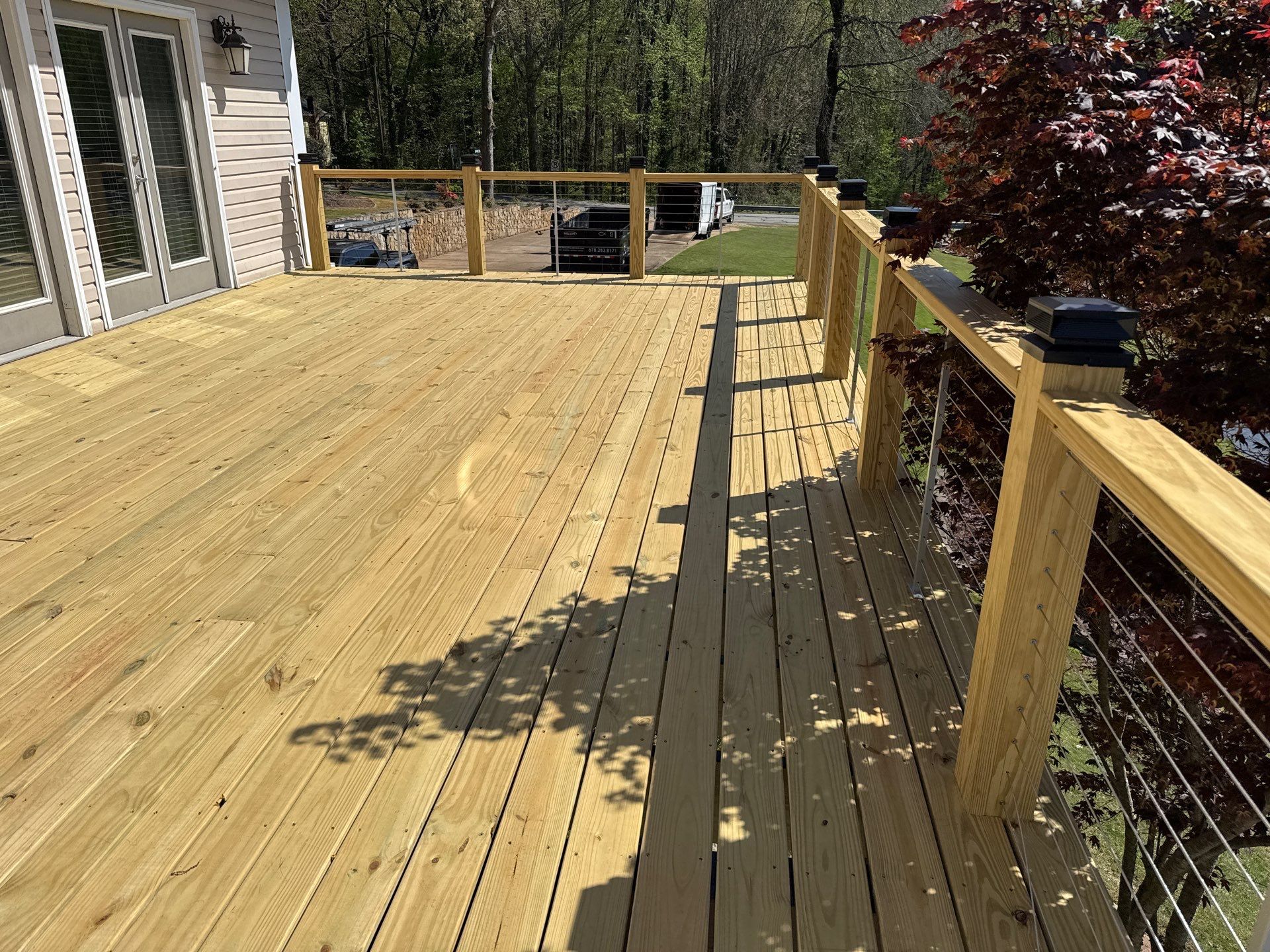 Cumming, GA Lake House Deck Resurface and Extension using Pressure Treated Pine and Skyline Cable Railing by Nelson Exteriors 