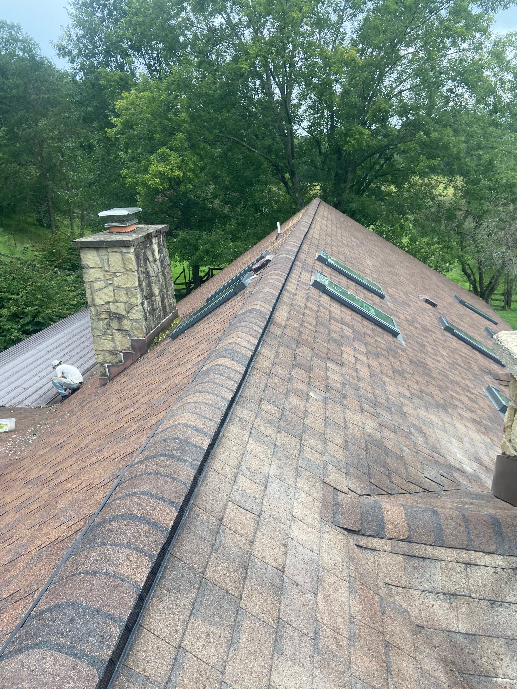 Shingle Roofing with Velux Skylight replacement and stone chimney flashing  by Secure Construction Company Inc