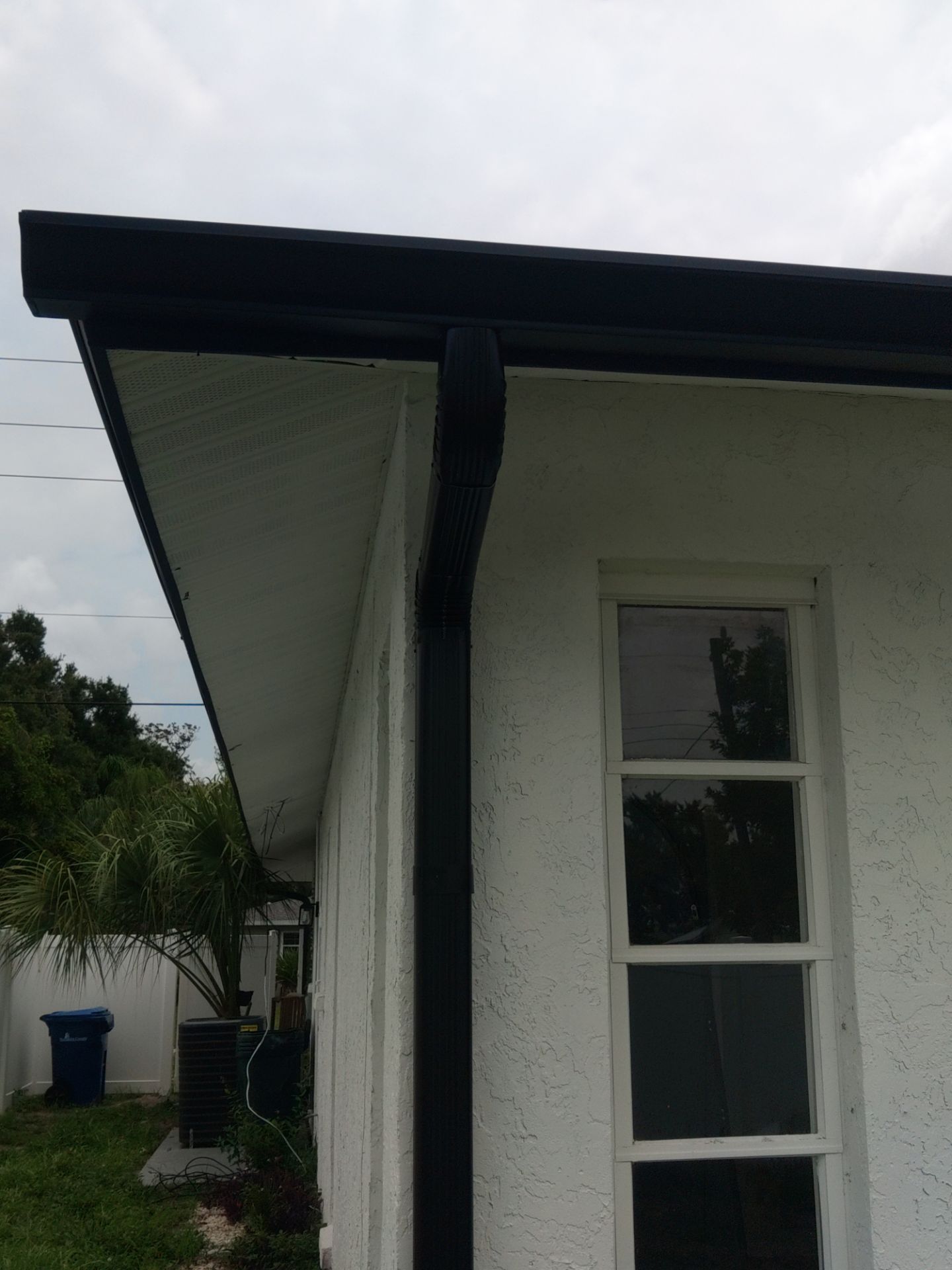 Black seamless gutters and downspouts installation in Sarasota, FL by Gutter Professors