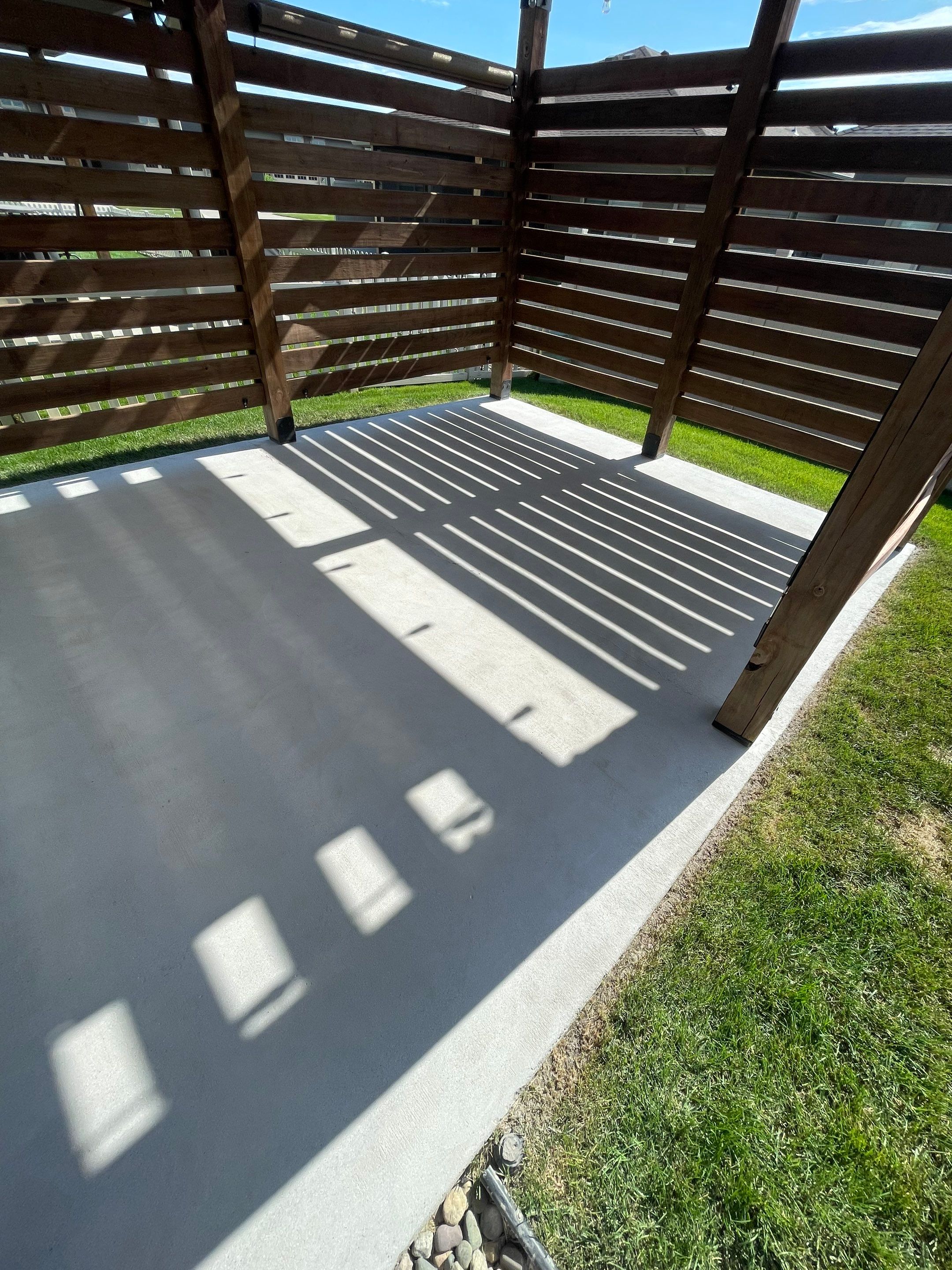 Textured Concrete Patio Coating and Custom Privacy Pergola in Sioux Falls by Select Painting, Coatings & Garage Cabinets
