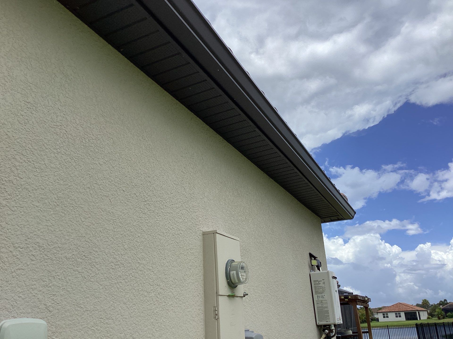 Musket brown seamless gutters with splash guards, new downspouts, and extensions in Bradenton, FL by Gutter Professors