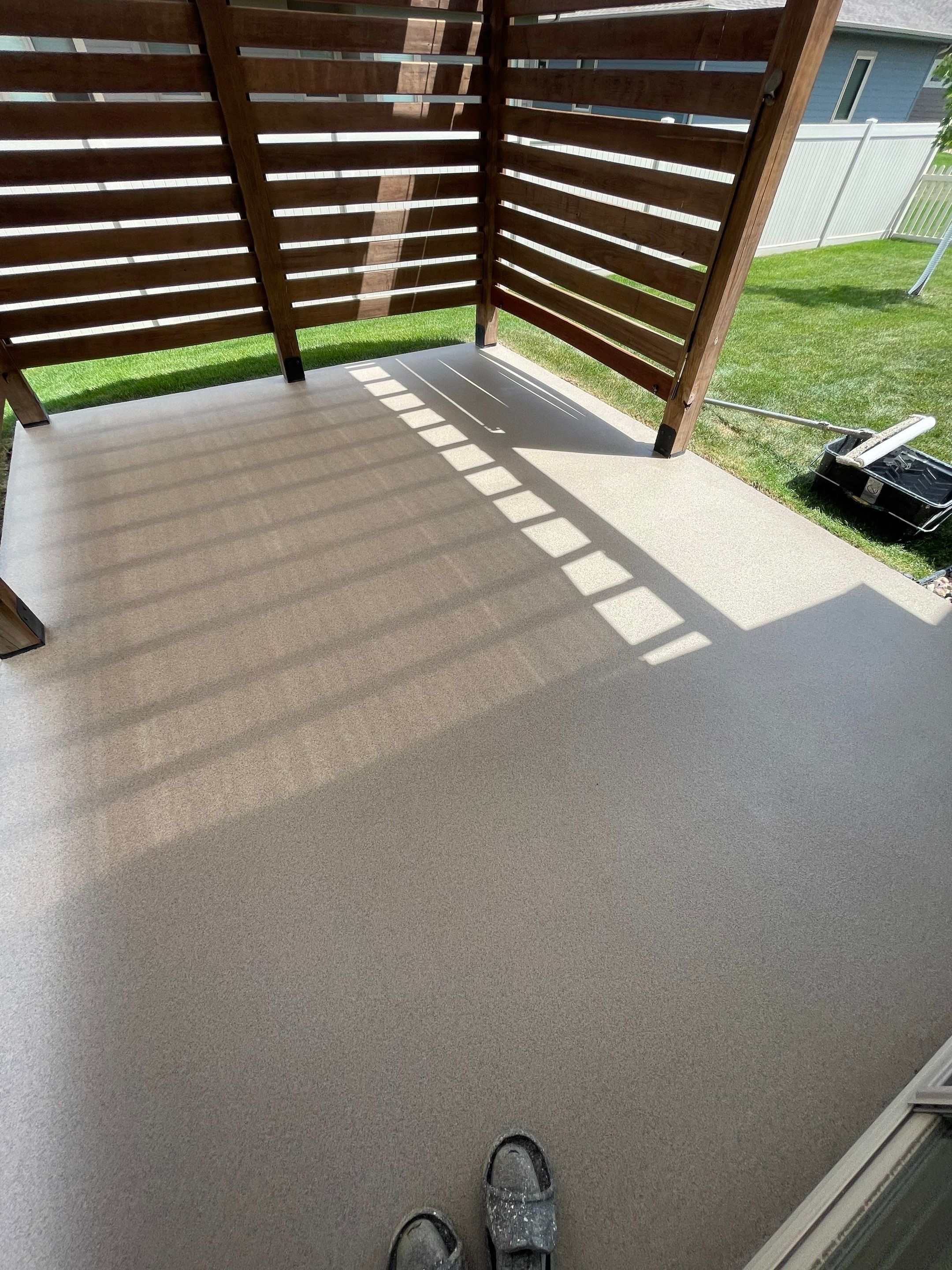 Textured Concrete Patio Coating and Custom Privacy Pergola in Sioux Falls by Select Painting, Coatings & Garage Cabinets
