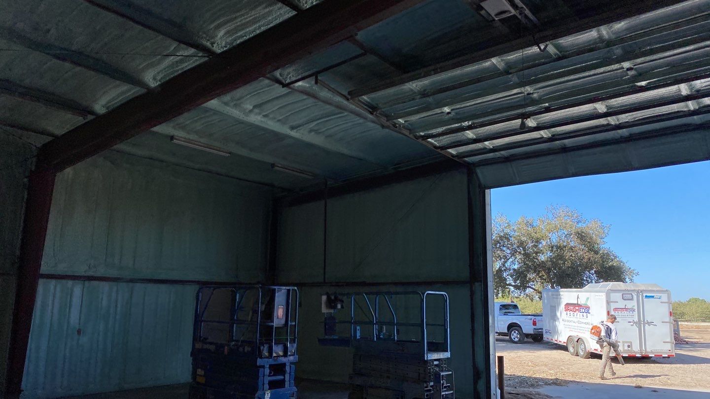 Spray foam insulation on inside of metal industrial building by Straight Edge Roofing Inc
