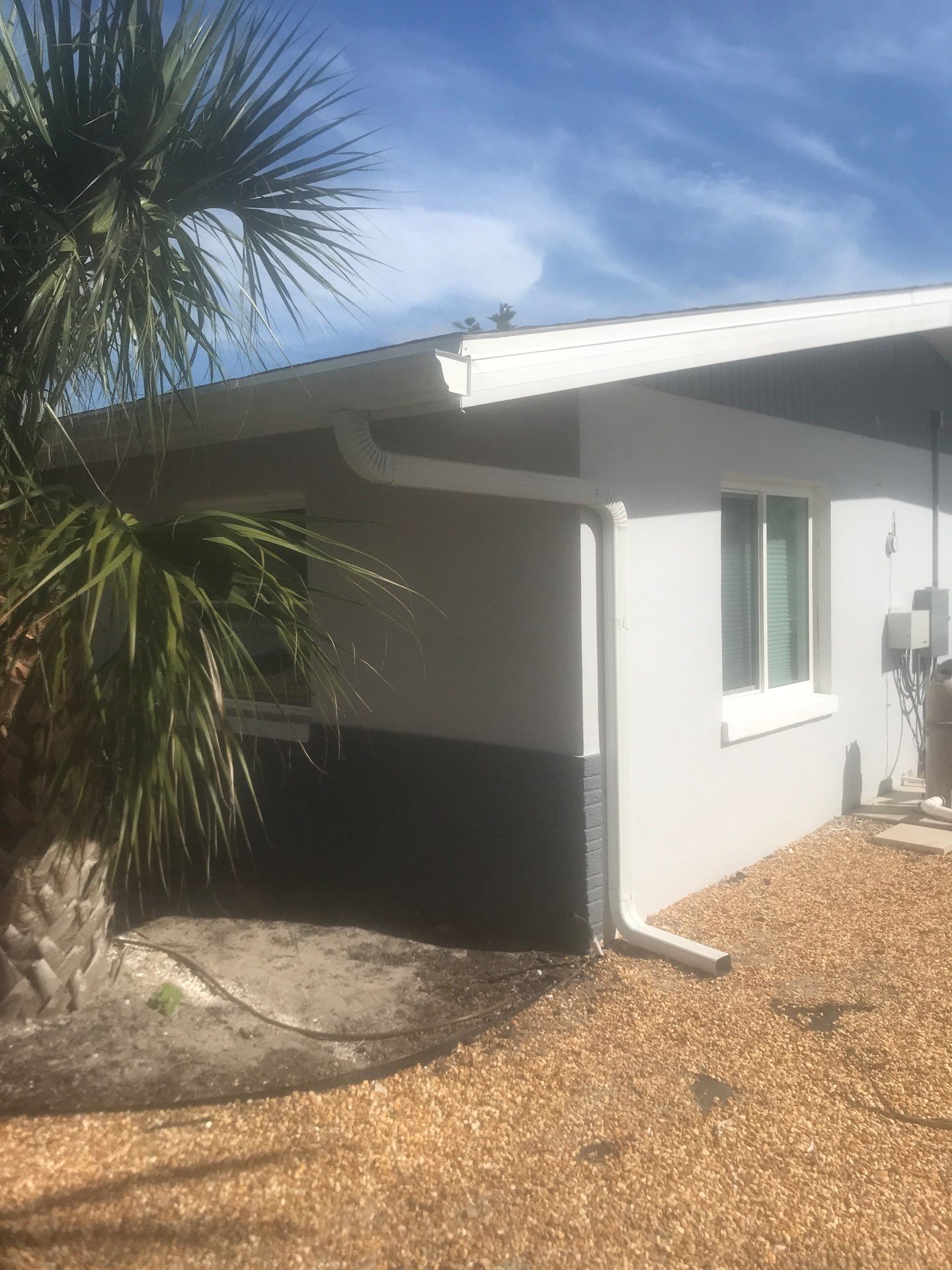 White Seamless Gutters with Matching Downspouts in Fort Myers Beach FL by Gutter Professors