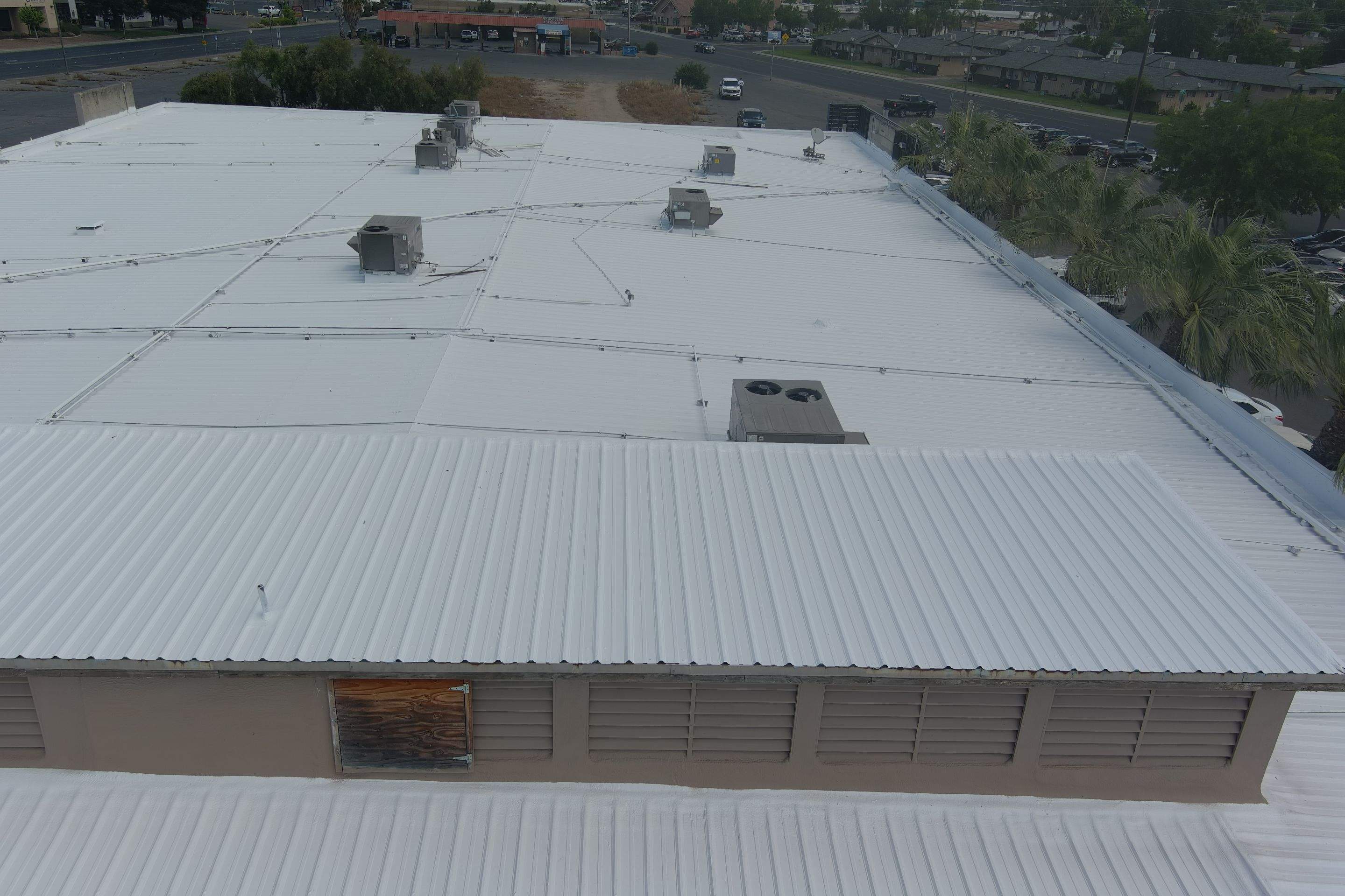 Metal roof restoration on commercial roof using Conklin Benchmark/ PUMA XL acrylic coatings over metal and foam by Straight Edge Roofing Inc