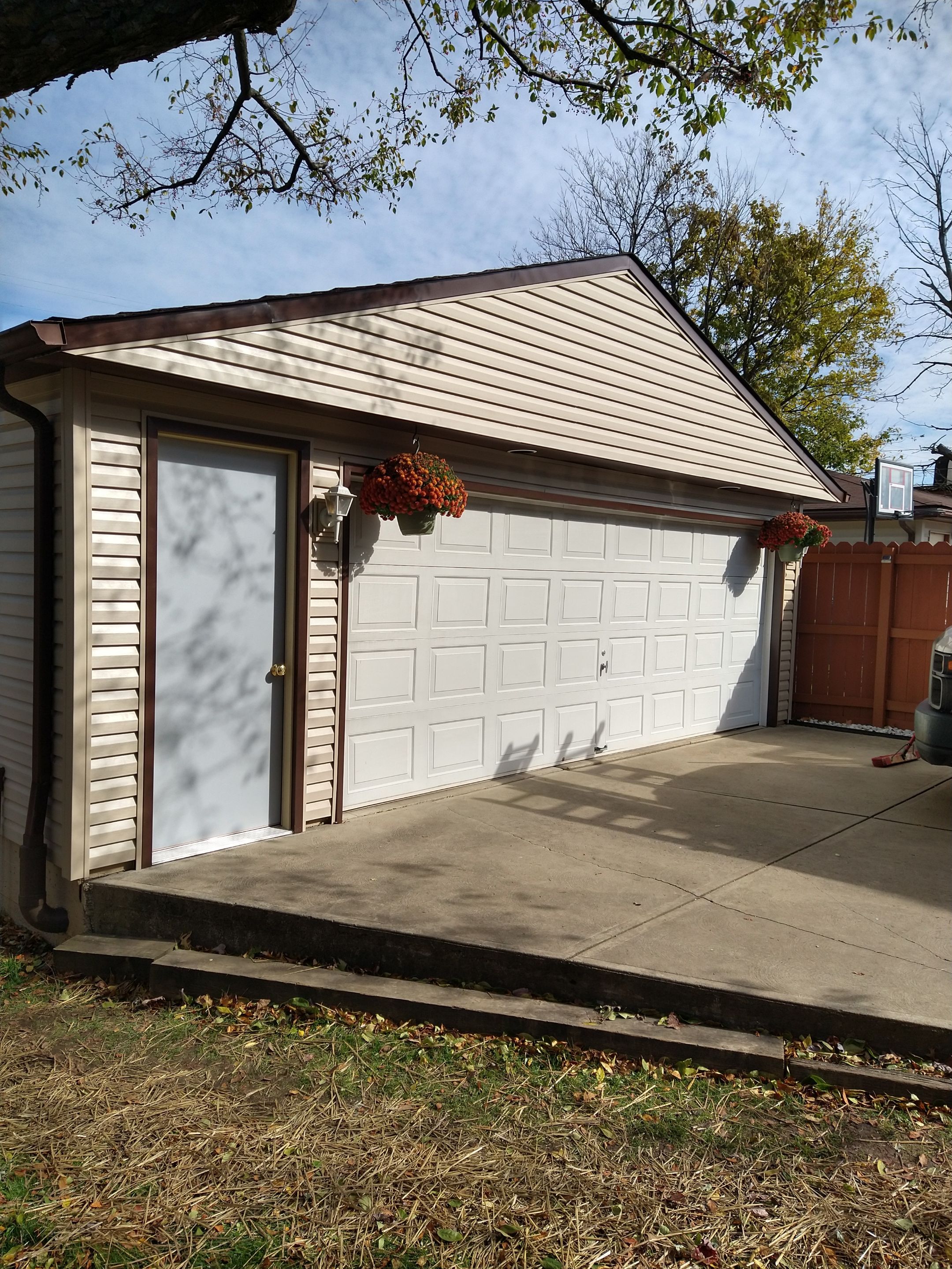 Siding Installation using Norandex woodsman dl-5 white woodgrain vinyl by Absolute Roofing and Construction