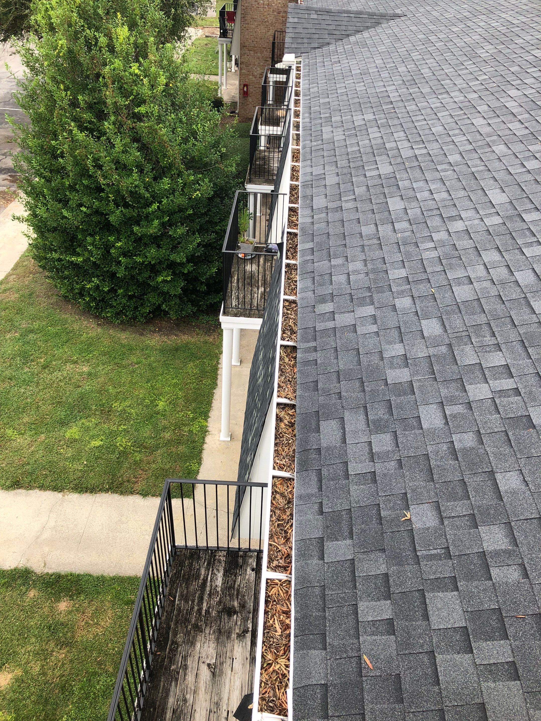 Commercial gutter cleaning Jacksonville, NC before photo with filled gutters