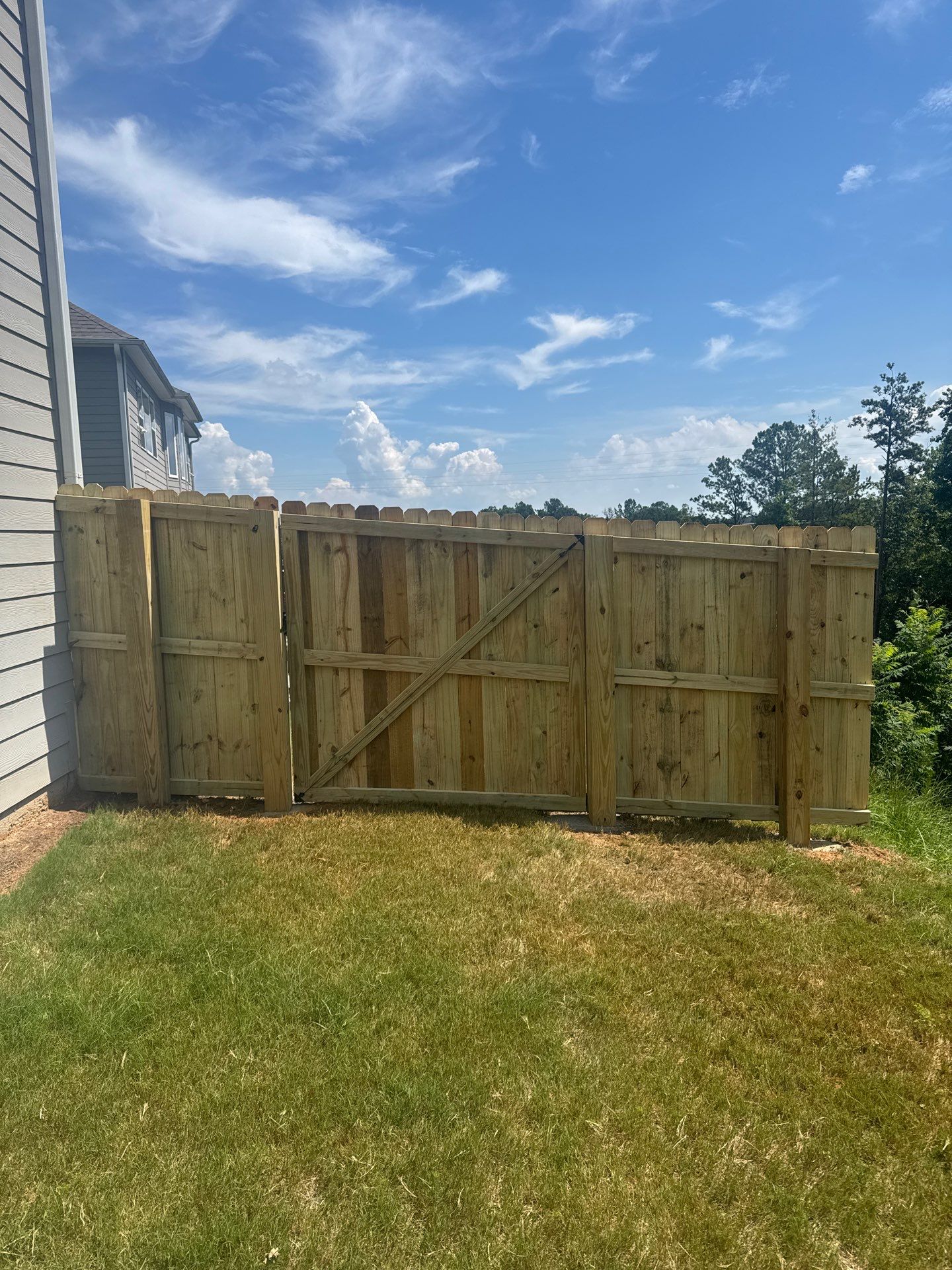 Ground-Level Gray Composite Deck and Privacy Fence Installation by Swift Home Renovations