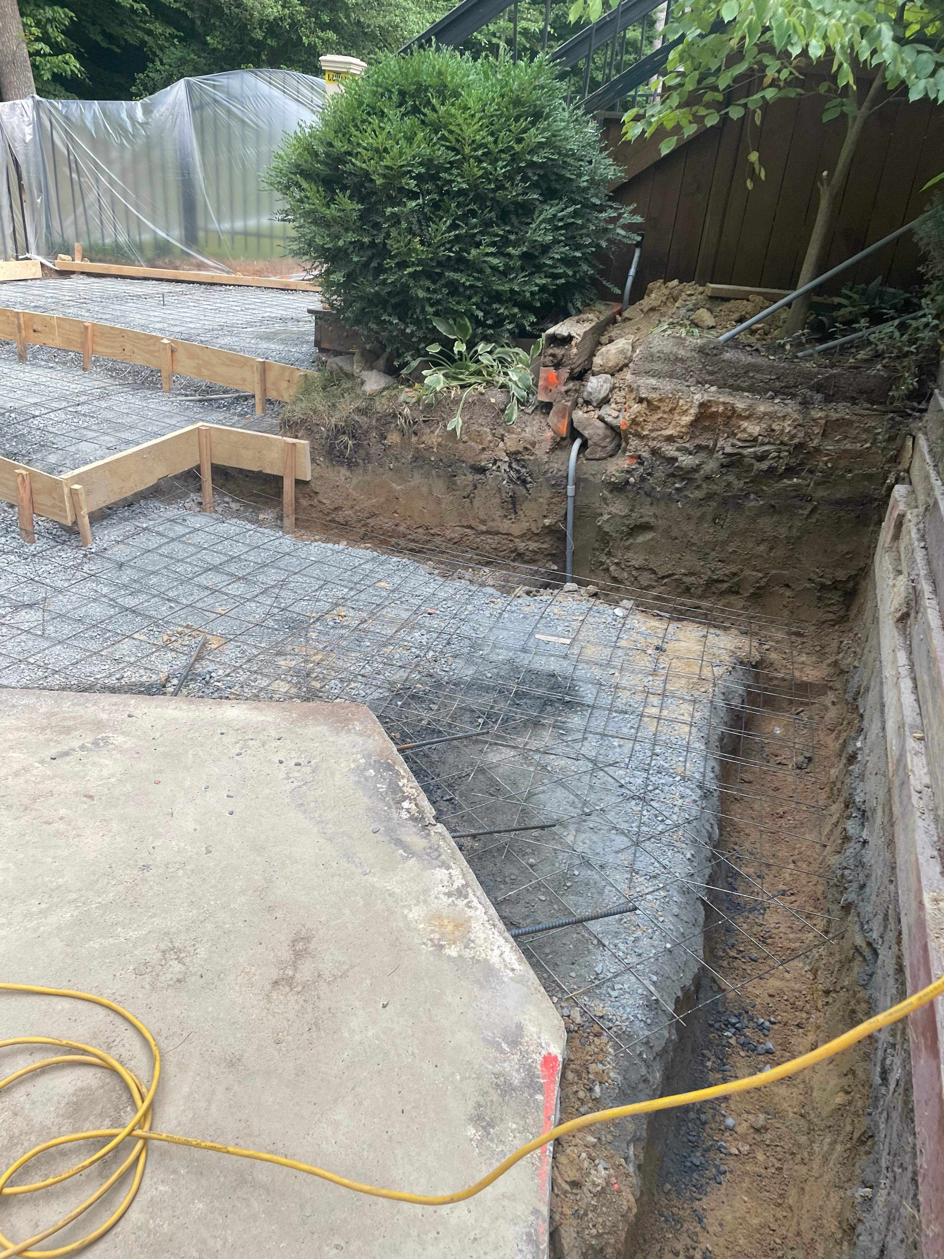 Pool Surround remodel with retaining walls, new waterfall and water slide by Fairfax Contractors, LLC