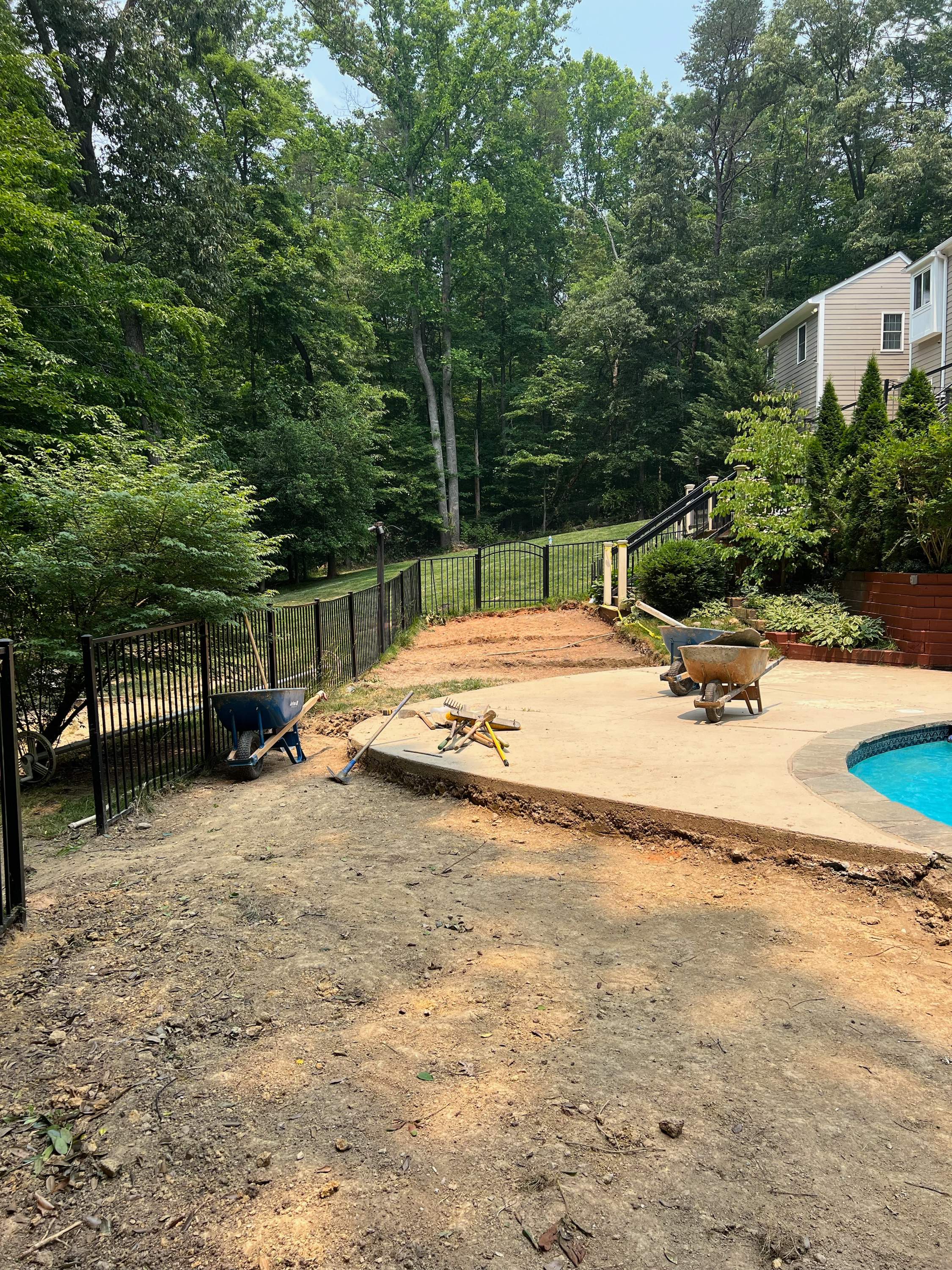 Pool Surround remodel with retaining walls, new waterfall and water slide by Fairfax Contractors, LLC