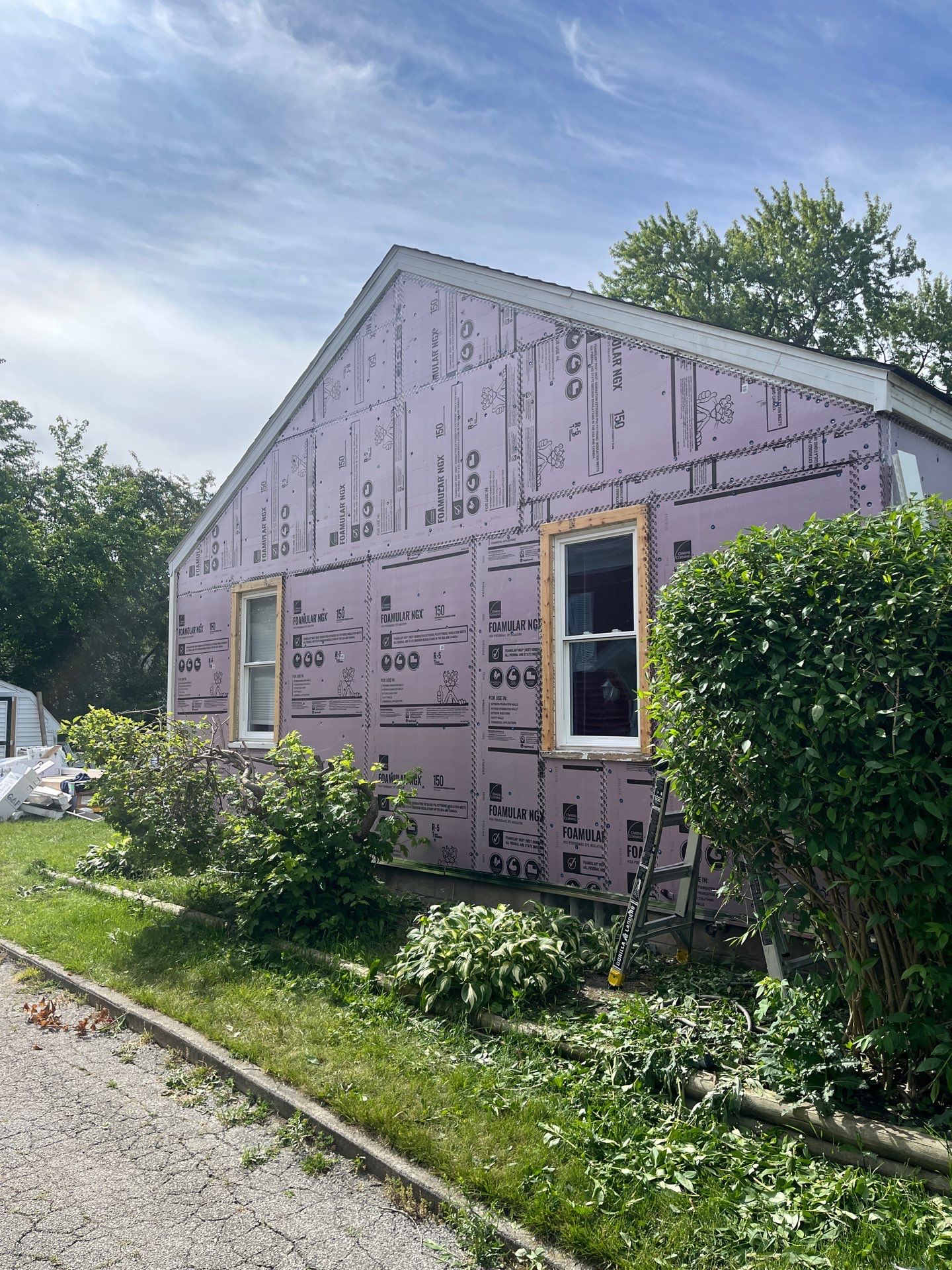 Blue Vinyl Siding and Versetta Stone Exterior Remodel in Bay City by Great Lakes Home Design LLC