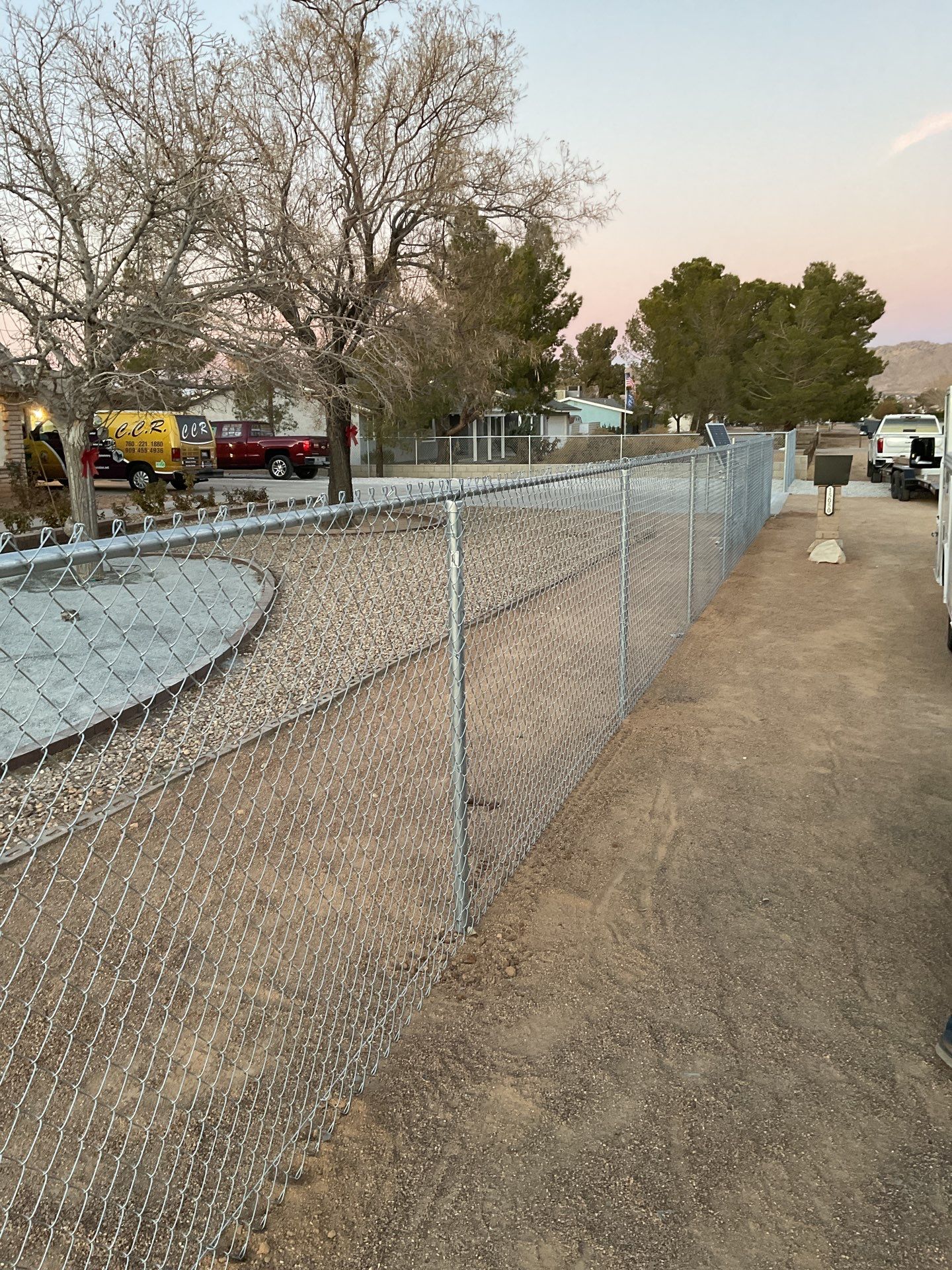 Sleek chain link fence installation with a solar motorized gate by Fence Guys Inc.