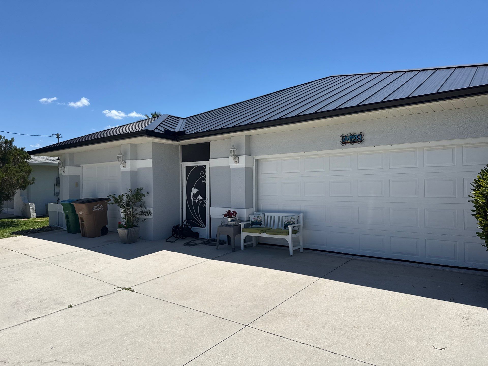 Black Seamless Gutters and White Downspouts in Cape Coral FL by Gutter Professors