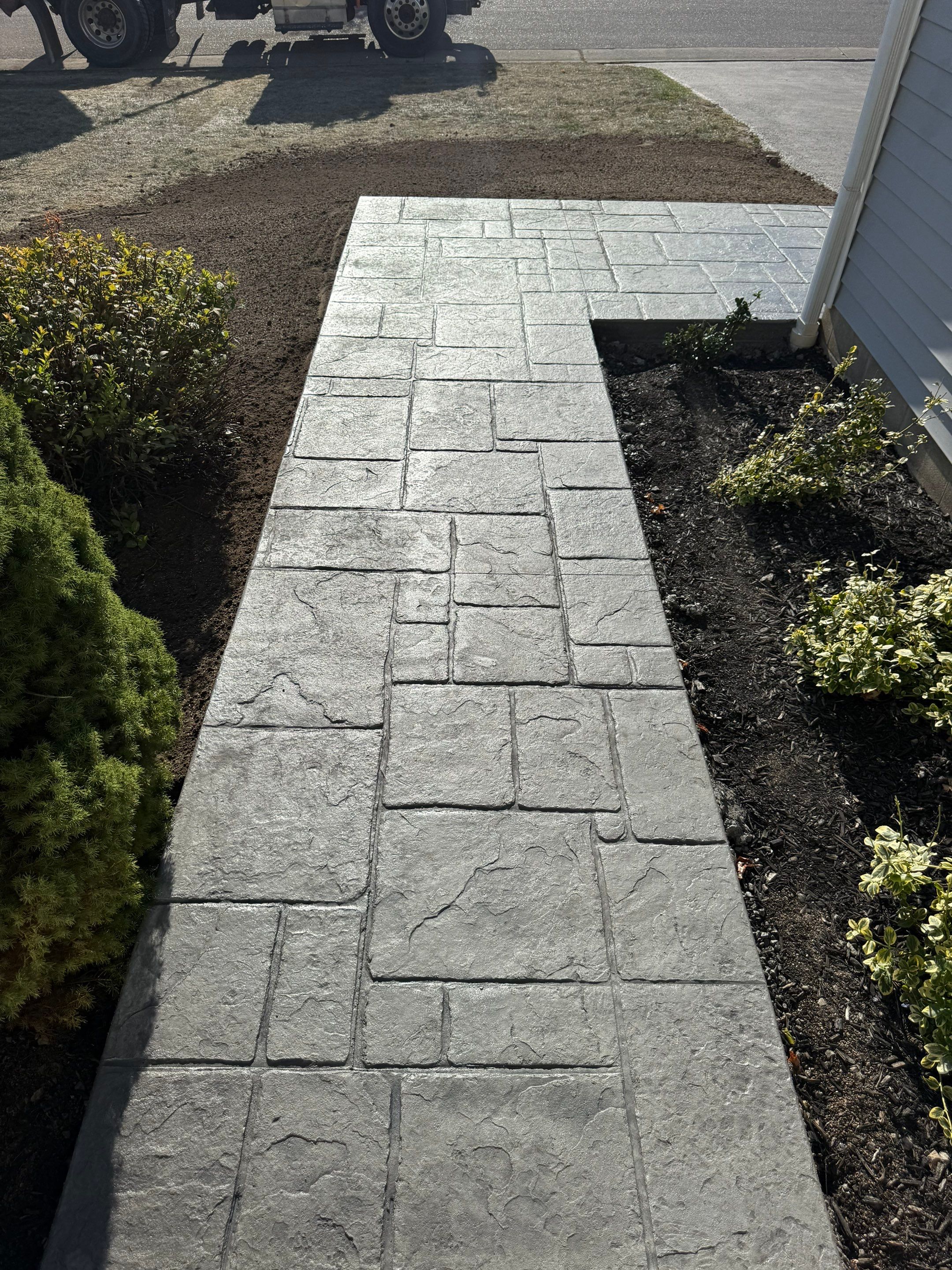Stamped English Rivenstone concrete patio and sidewalks  by NG Masonry & Construction LLC