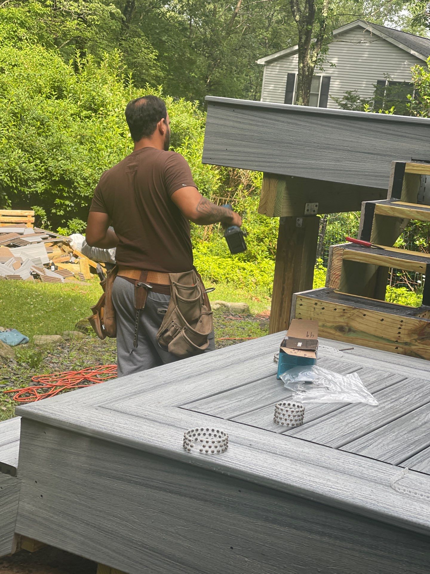 Raised Gray Composite Deck and Staircase Construction in Pocono Summit, PA by Herts Roofing & Construction