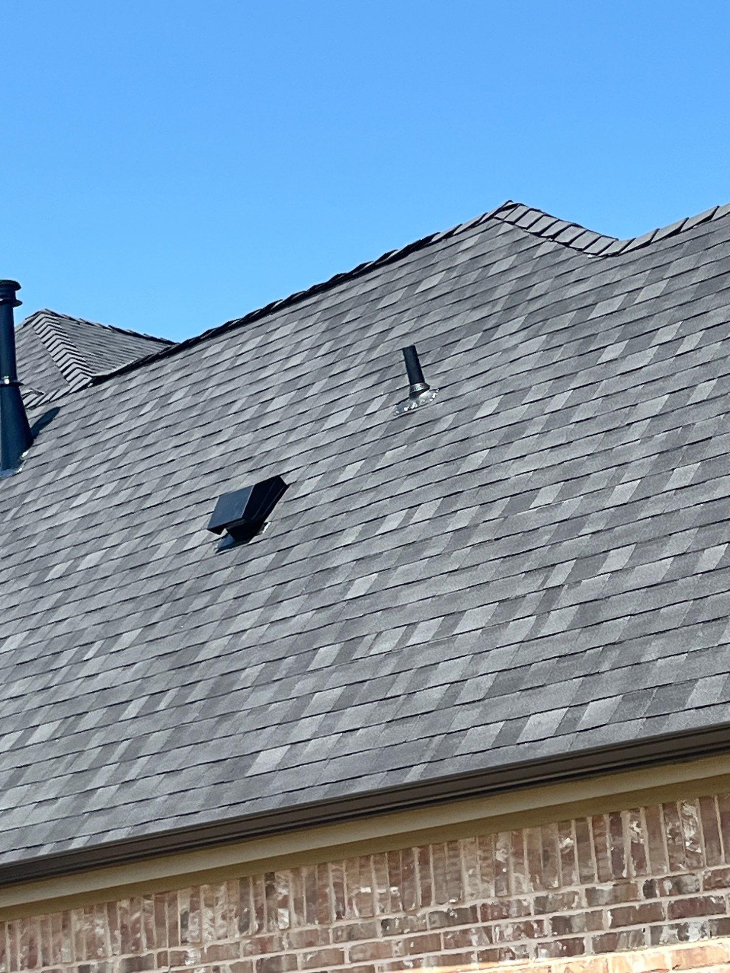 IKO Granite Black-Light Brown with dark brown sections brick house  by Tejas Roofworks + Restoration