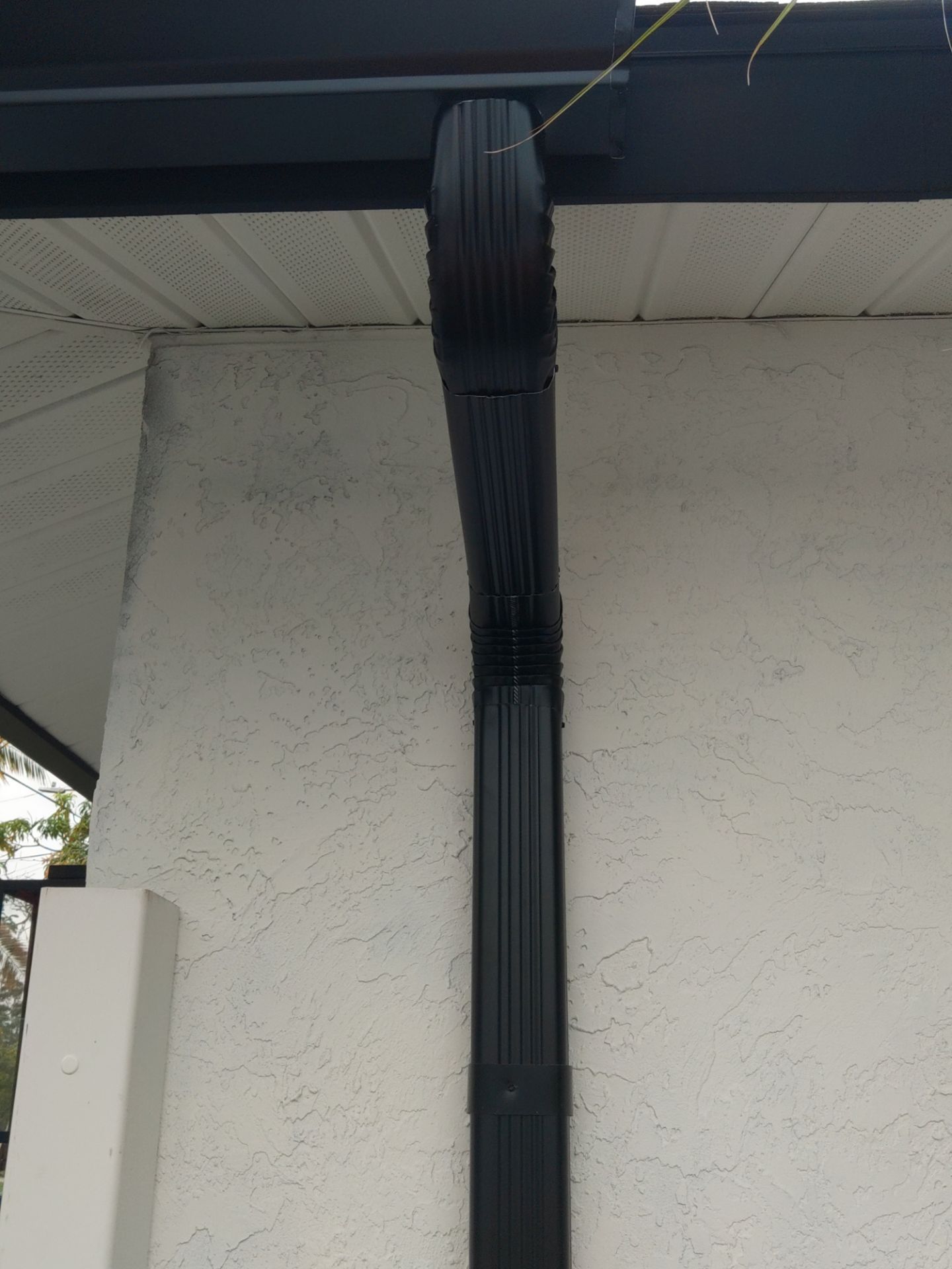 Black seamless gutters and downspouts installation in Sarasota, FL by Gutter Professors
