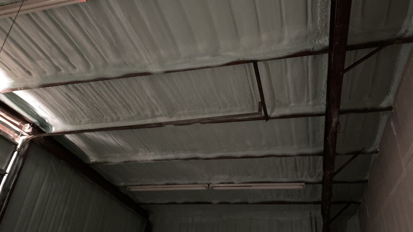 Spray foam insulation on inside of metal industrial building by Straight Edge Roofing Inc