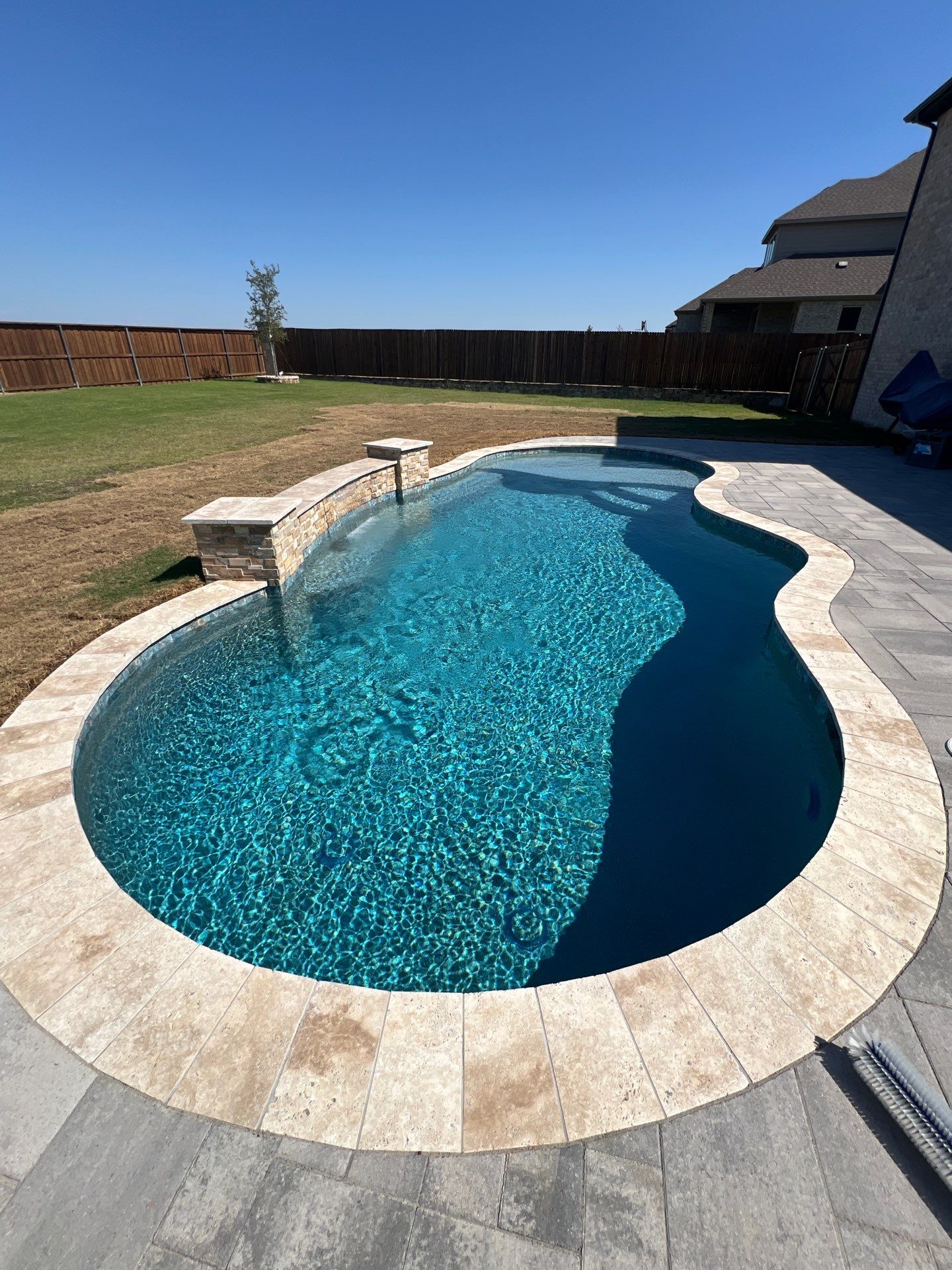 Freeform Pool with Raised Stone Accent Wall by Pinnacle Pools and Spas - DFW