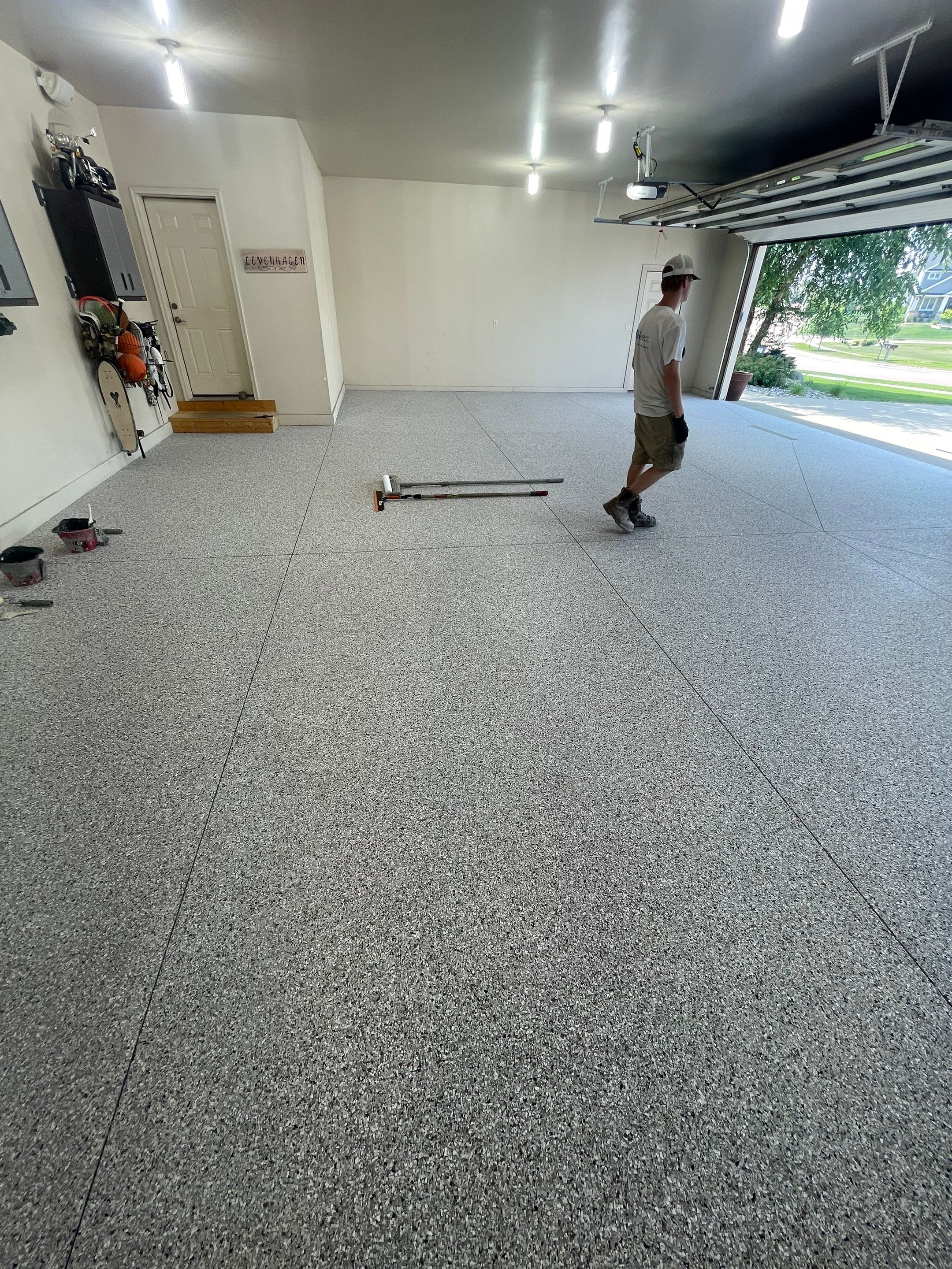 Coyote Flake Garage Floor Coating in Sioux Falls with Trench Drain by Select Painting, Coatings & Garage Cabinets