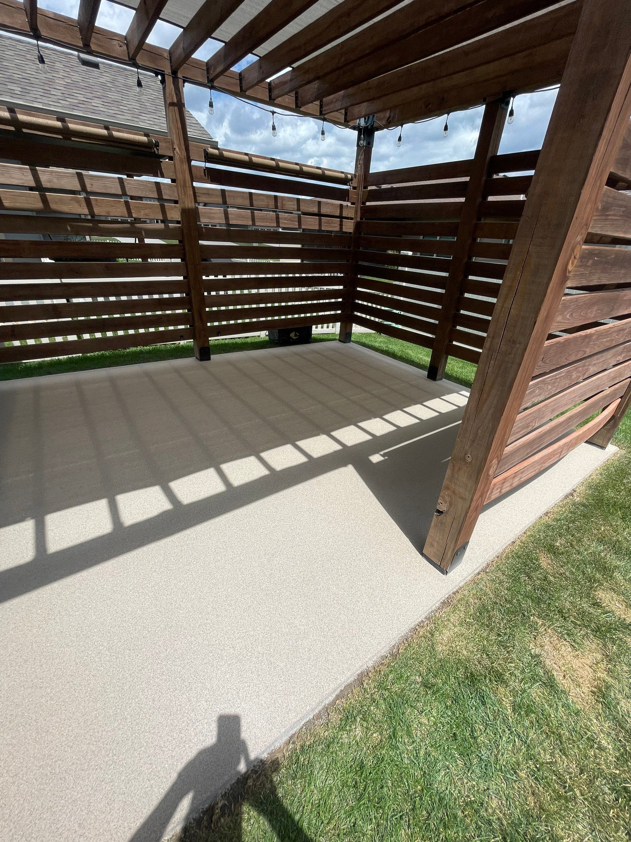 Textured Concrete Patio Coating and Custom Privacy Pergola in Sioux Falls by Select Painting, Coatings & Garage Cabinets