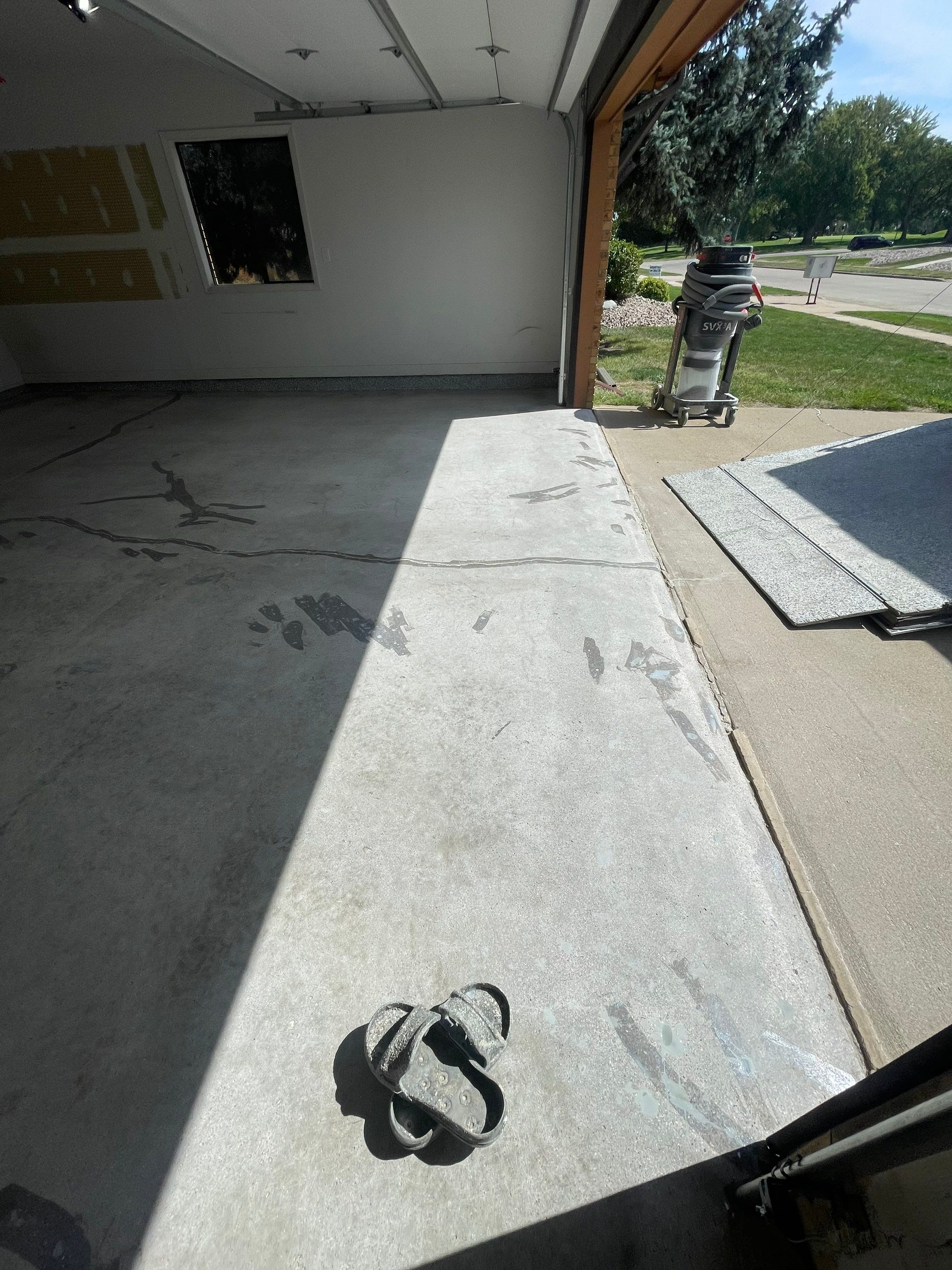 Grey Speckled Concrete Coating for Residential Garage in Yankton by Select Painting, Coatings & Garage Cabinets