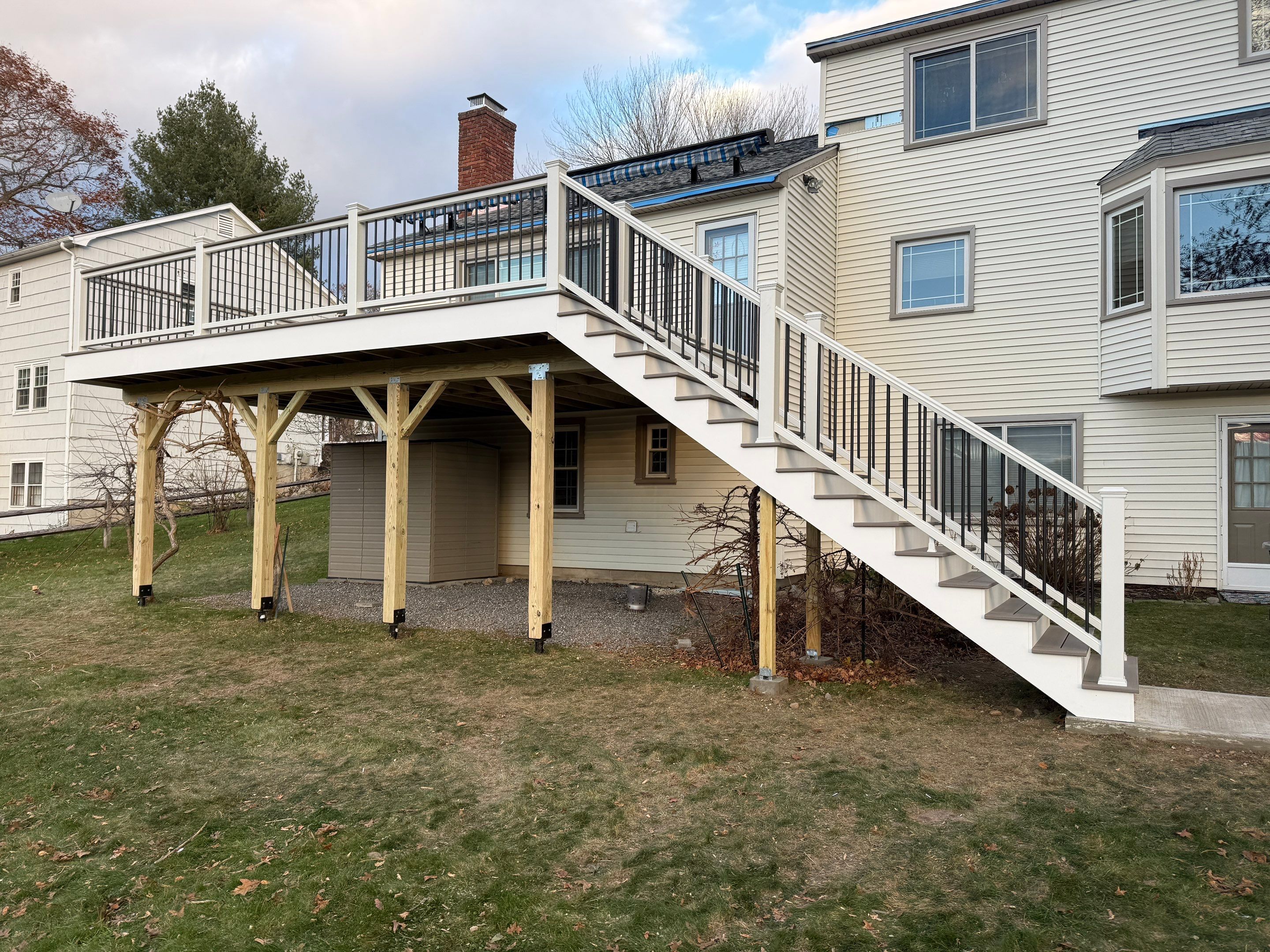 Replacement deck with Trex linage Biscayne boards and White Transcend railing with cocktail rail, and Trex gate. by DiGiorgi Roofing and Siding Inc