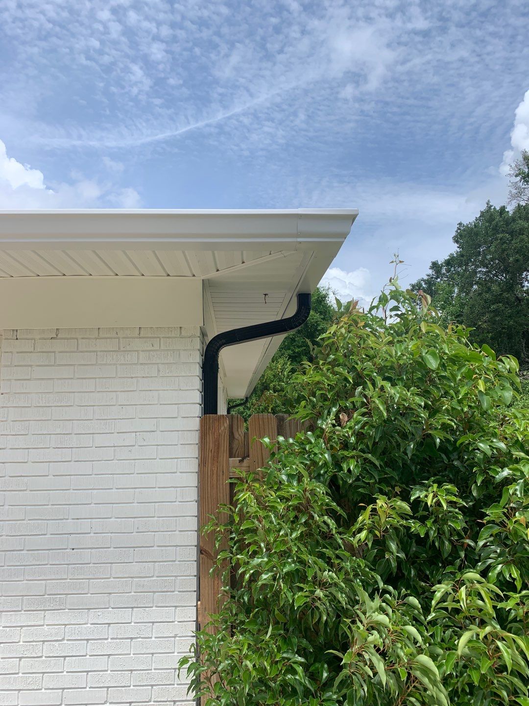 White Seamless Gutters and Black Downspouts by Gutter Professors