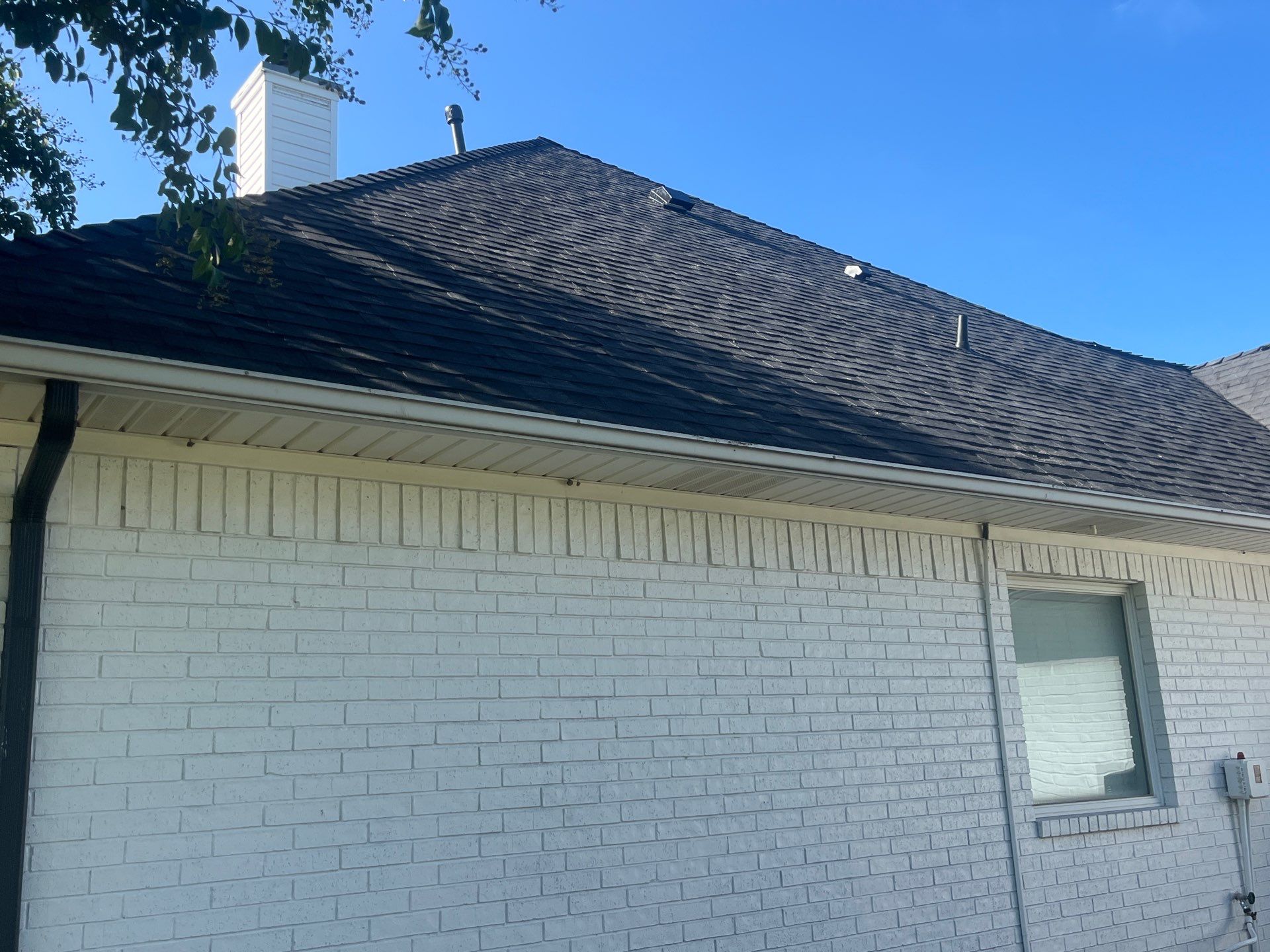 White brick with Malarkey Brilliant Black by Tejas Roofworks + Restoration