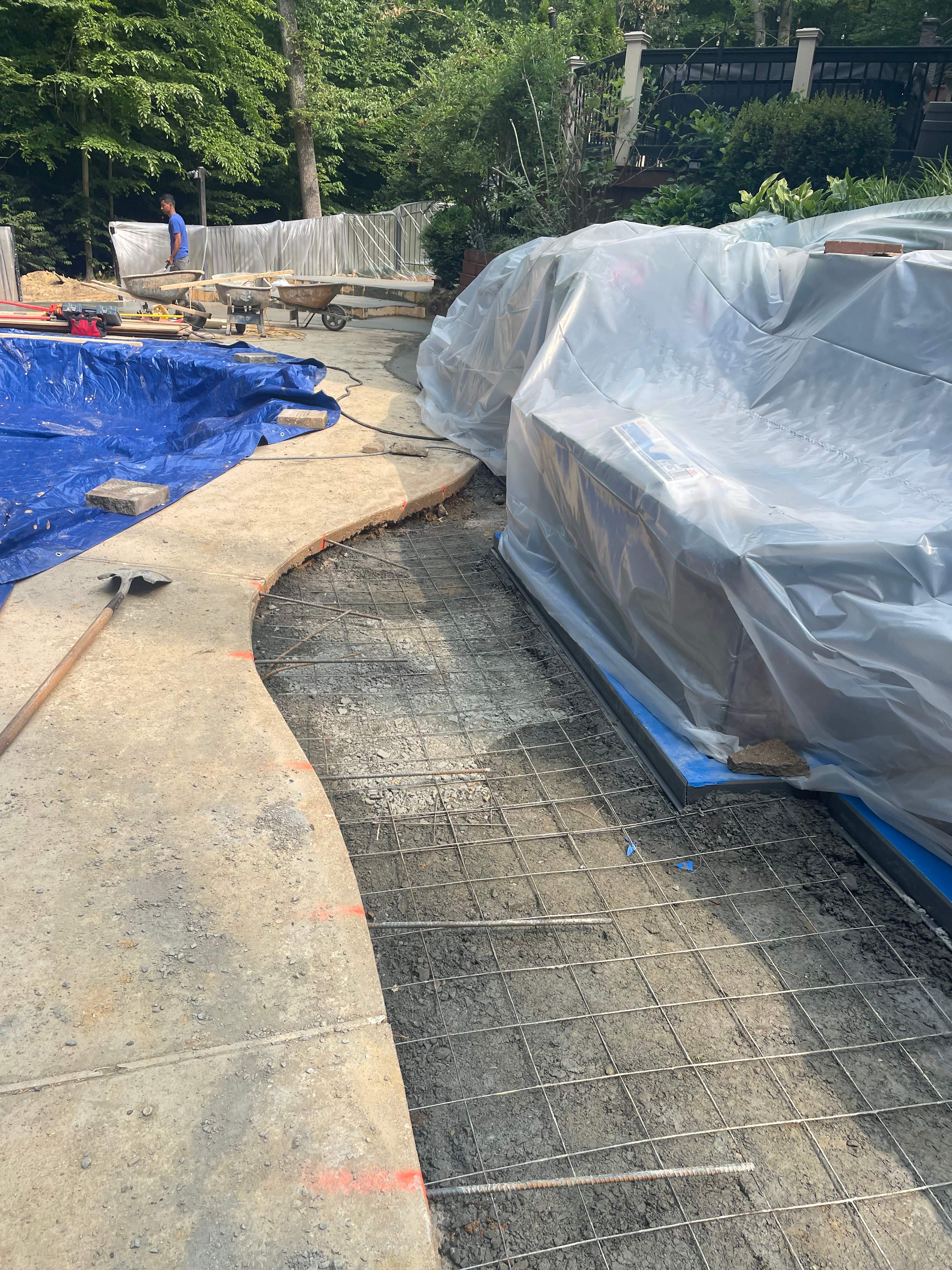 Pool Surround remodel with retaining walls, new waterfall and water slide by Fairfax Contractors, LLC