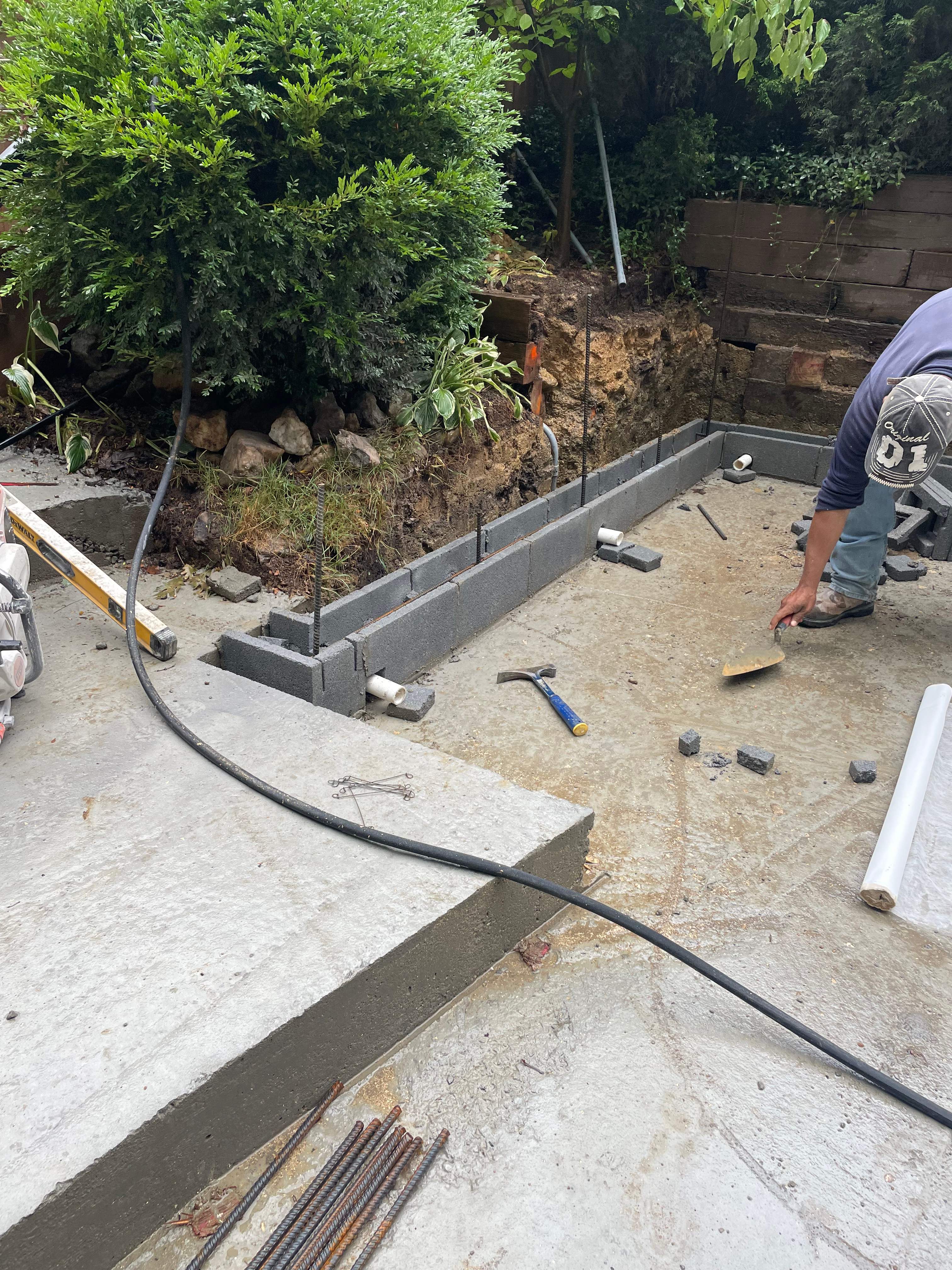 Pool Surround remodel with retaining walls, new waterfall and water slide by Fairfax Contractors, LLC