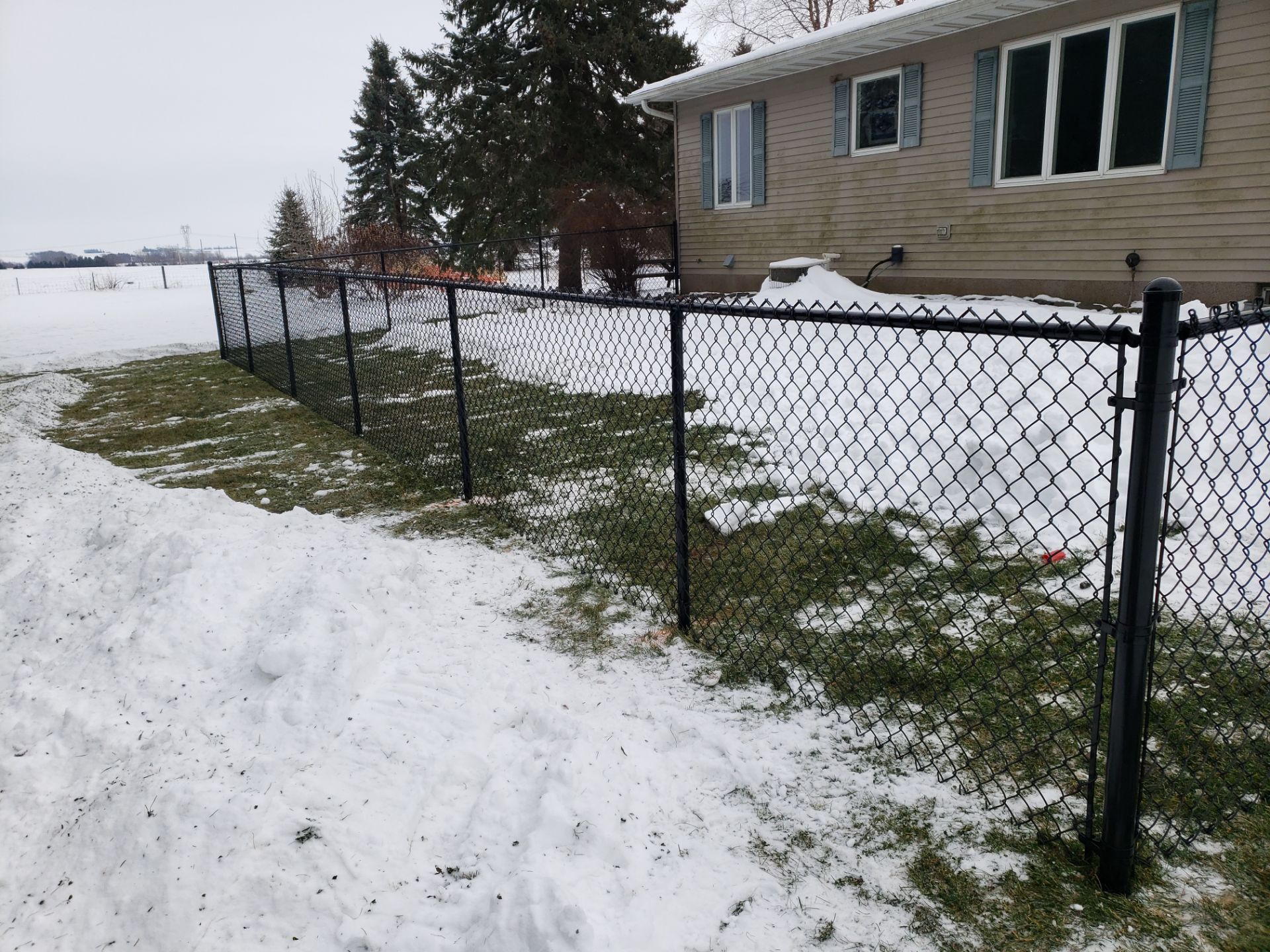 Black Vinyl-Coated Chain Link Fence Installation in Oelwein by Perfect Picket Fence and Stain