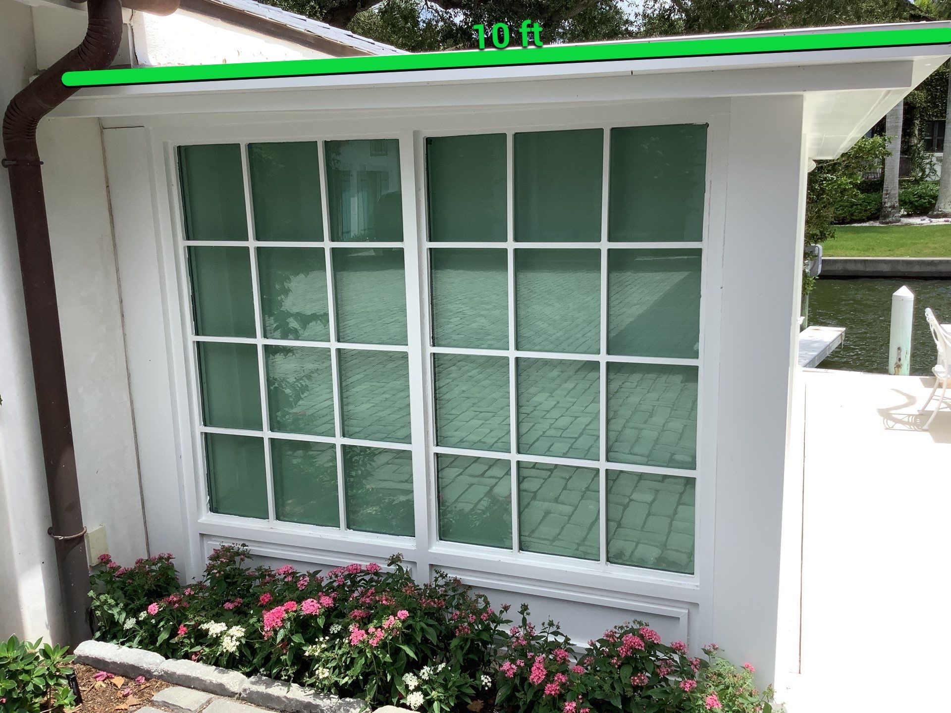 Seamless aluminum gutter installation in Sarasota, FL using 3x4 elbow downspouts combined with round downspouts by Gutter Professors