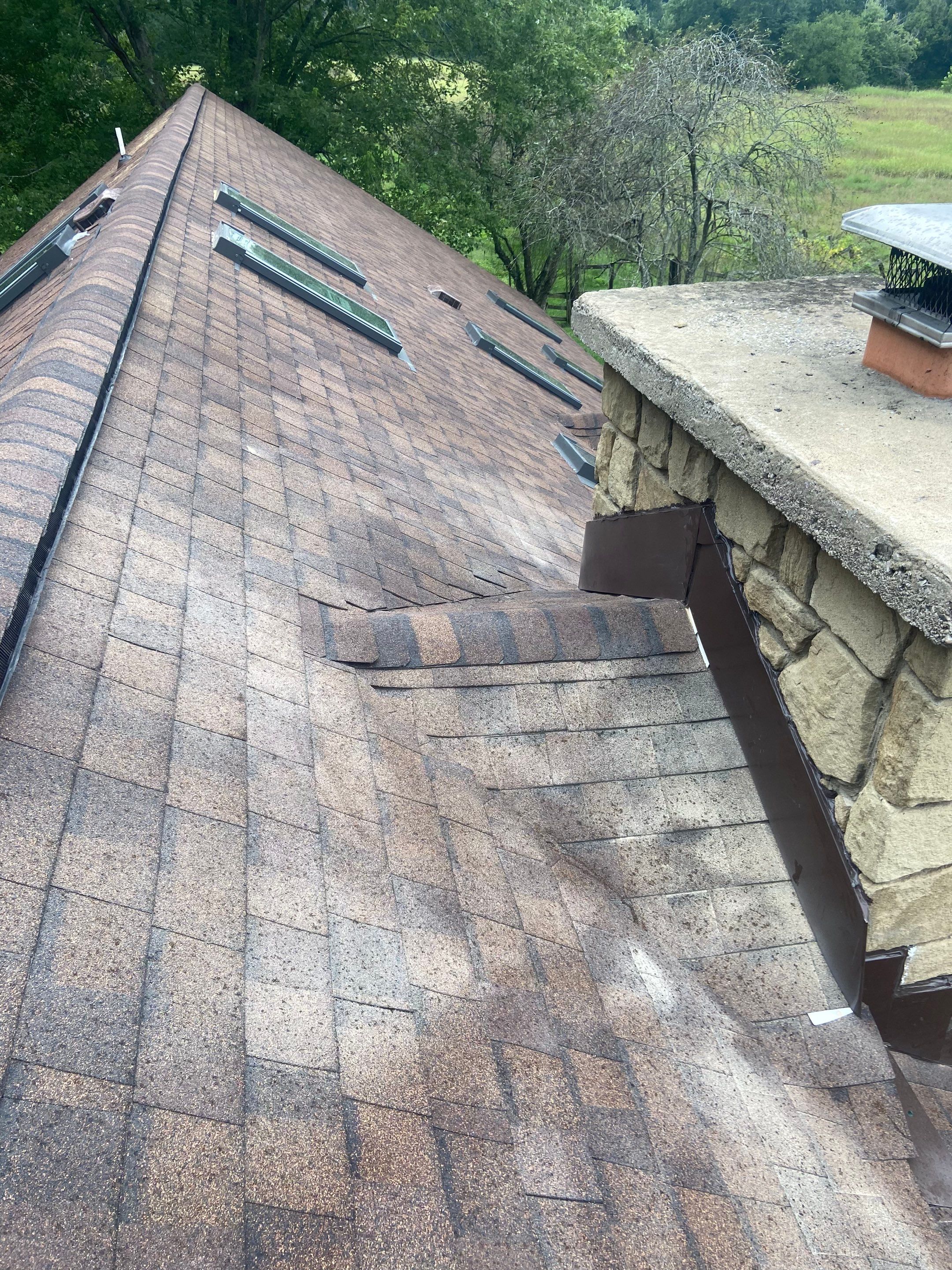 Shingle Roofing with Velux Skylight replacement and stone chimney flashing by Secure Construction Company Inc
