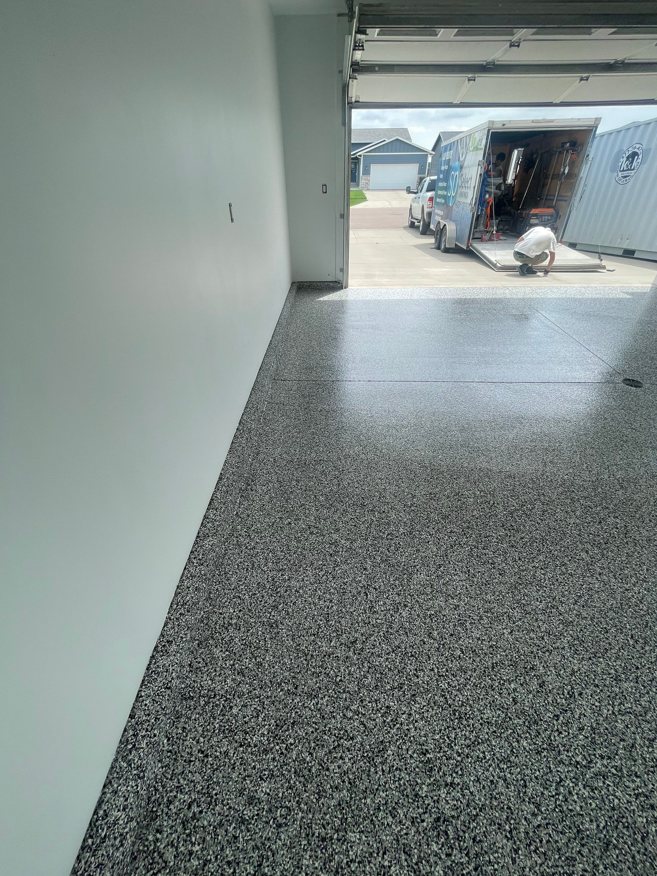 Grey Flake Epoxy Garage Floor Coating in Sioux Falls by Select Painting, Coatings & Garage Cabinets