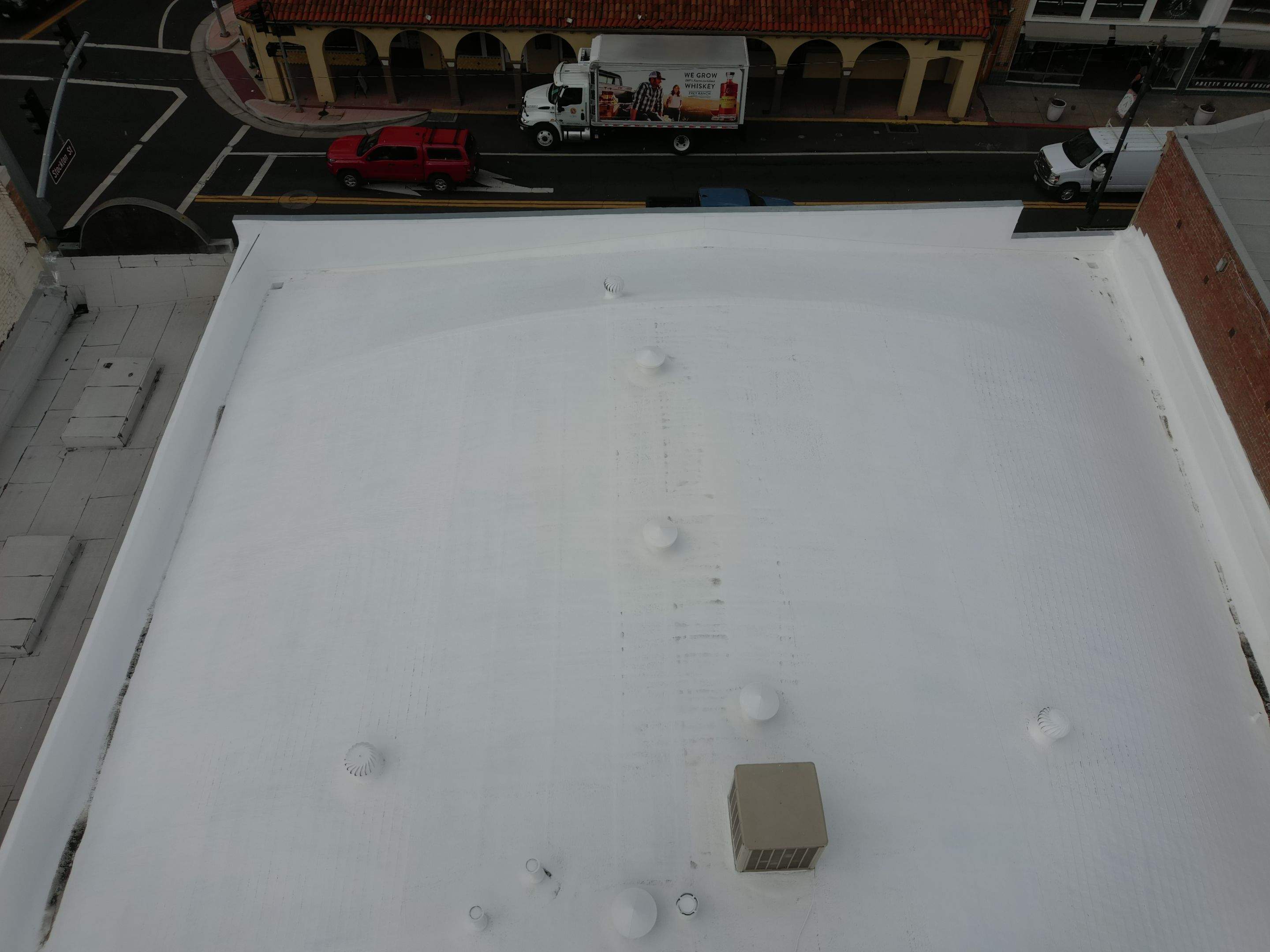 Foam and coatings on commercial roof by Straight Edge Roofing Inc