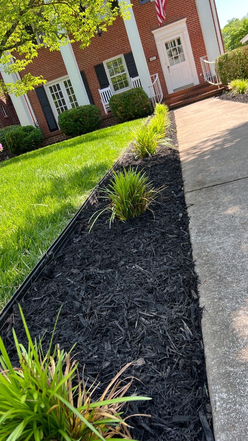 Liriope grasses, mulch and stone pavers by GrassBusters, Inc.