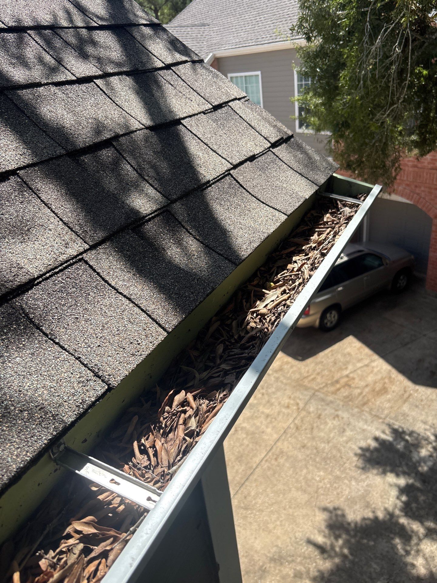 HOA gutter cleaning in Pearland, TX,before  photo showing full gutters.